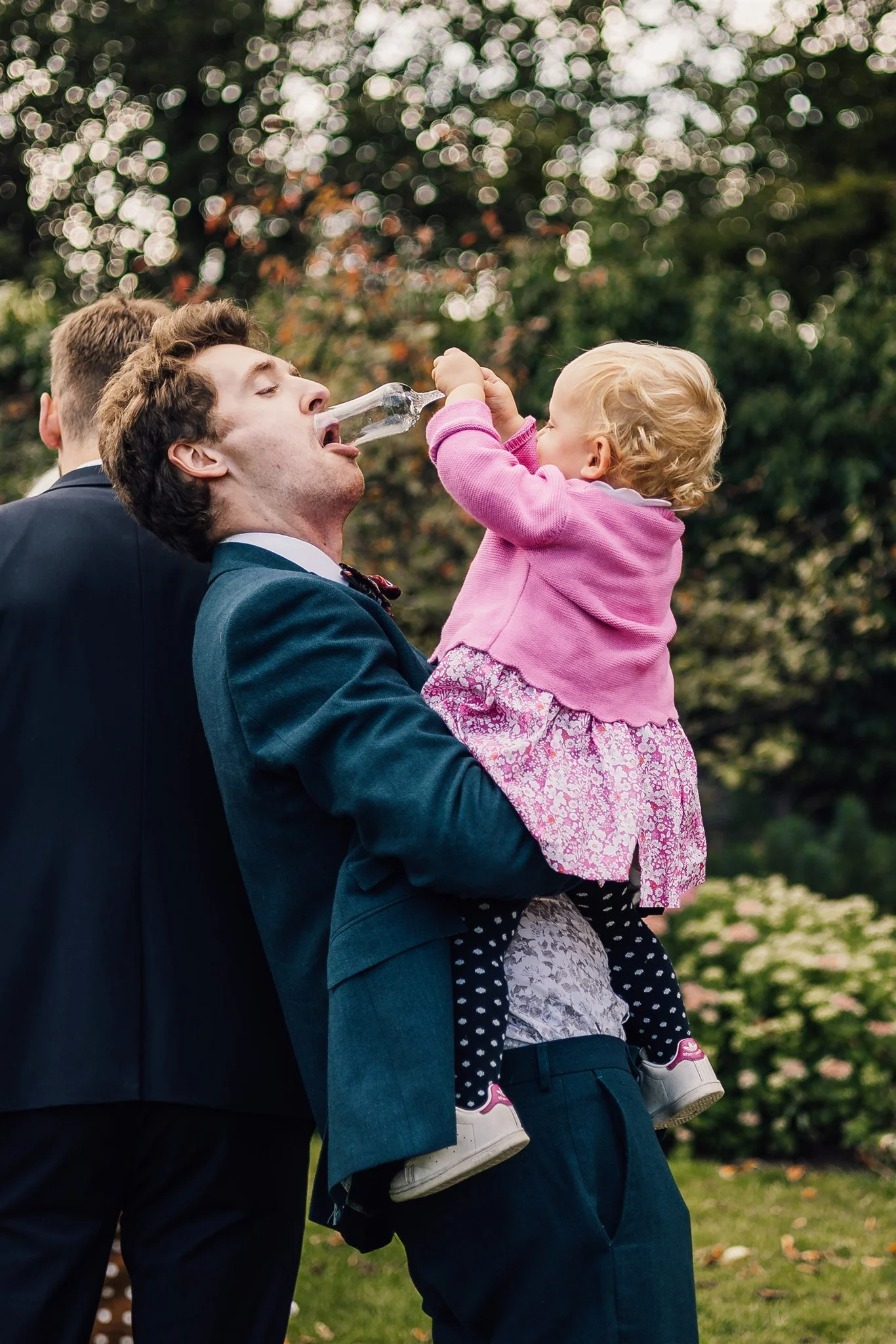 Candid wedding moment with guest and child playing at East Riddlesden Hall
