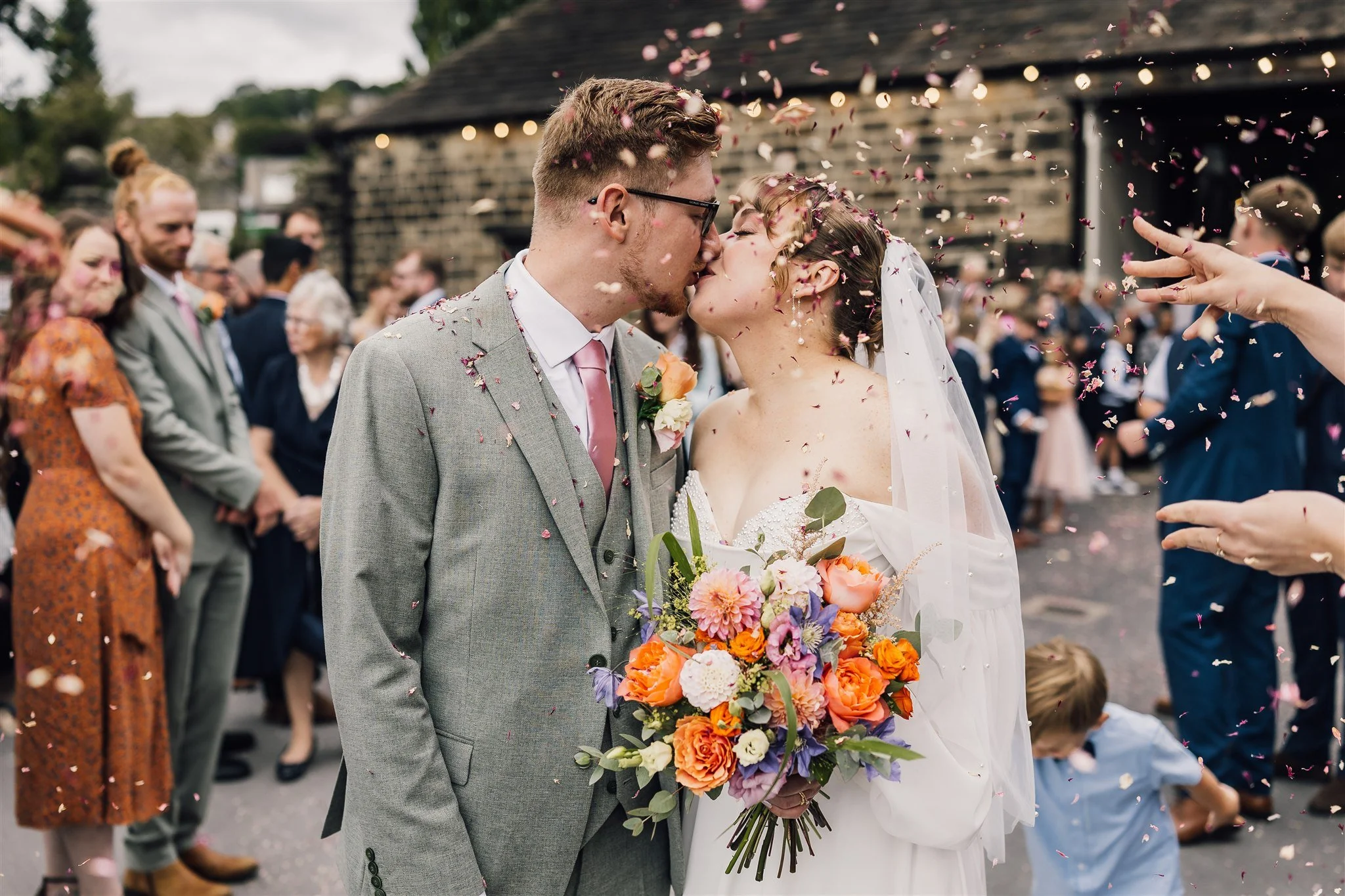 Bride and groom kissing during confetti moment at East Riddlesden Hall wedding