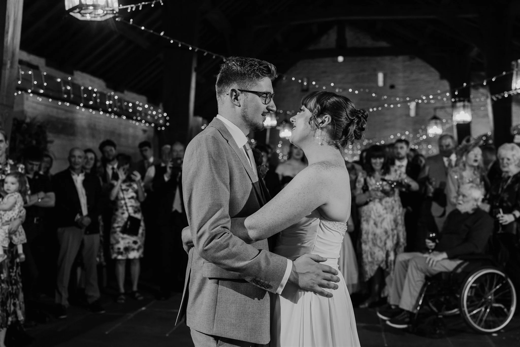 Bride and groom sharing their first dance at East Riddlesden Hall surrounded by guests