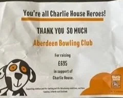A poster confirming a charity fund donation of £695 for Charlie House.