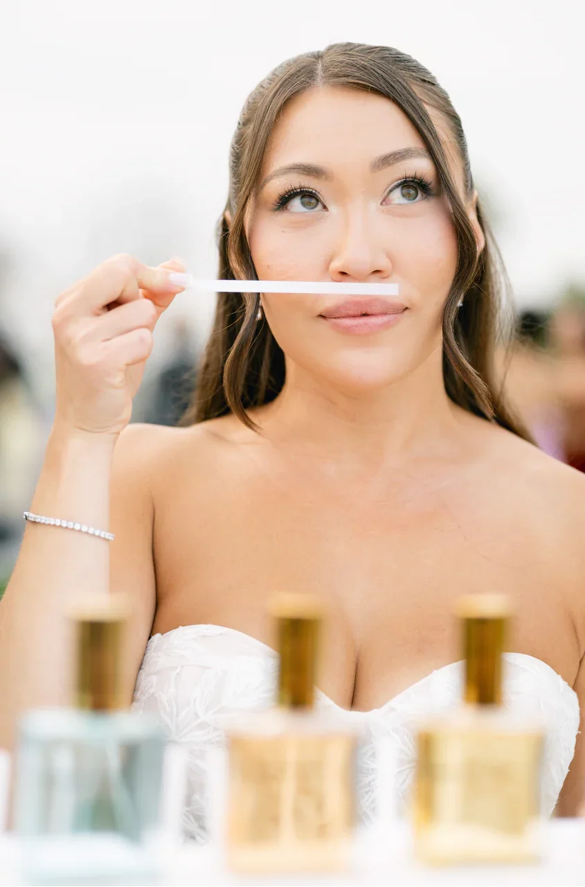 Bride smelling fragrance at a mobile perfume bar while creating a custom wedding perfume.