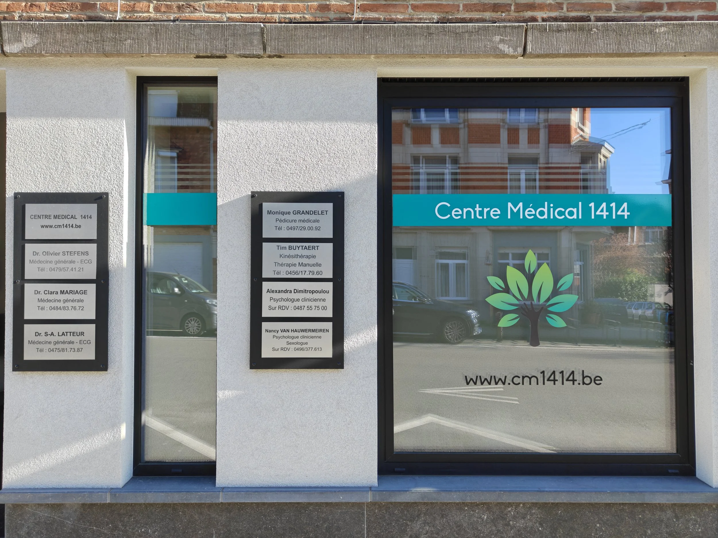Vitrine d'un centre médical avec panneaux d'information et logo d'un arbre vert sur la fenêtre