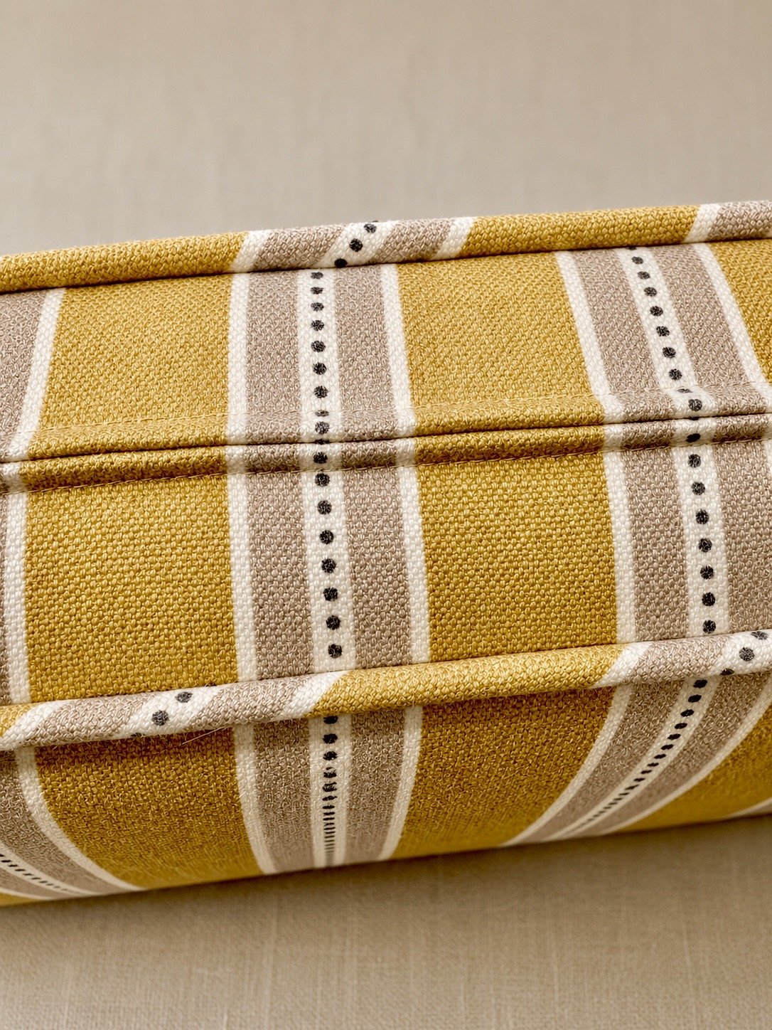 Close-up of a yellow and white striped fabric storage box with a textured surface.