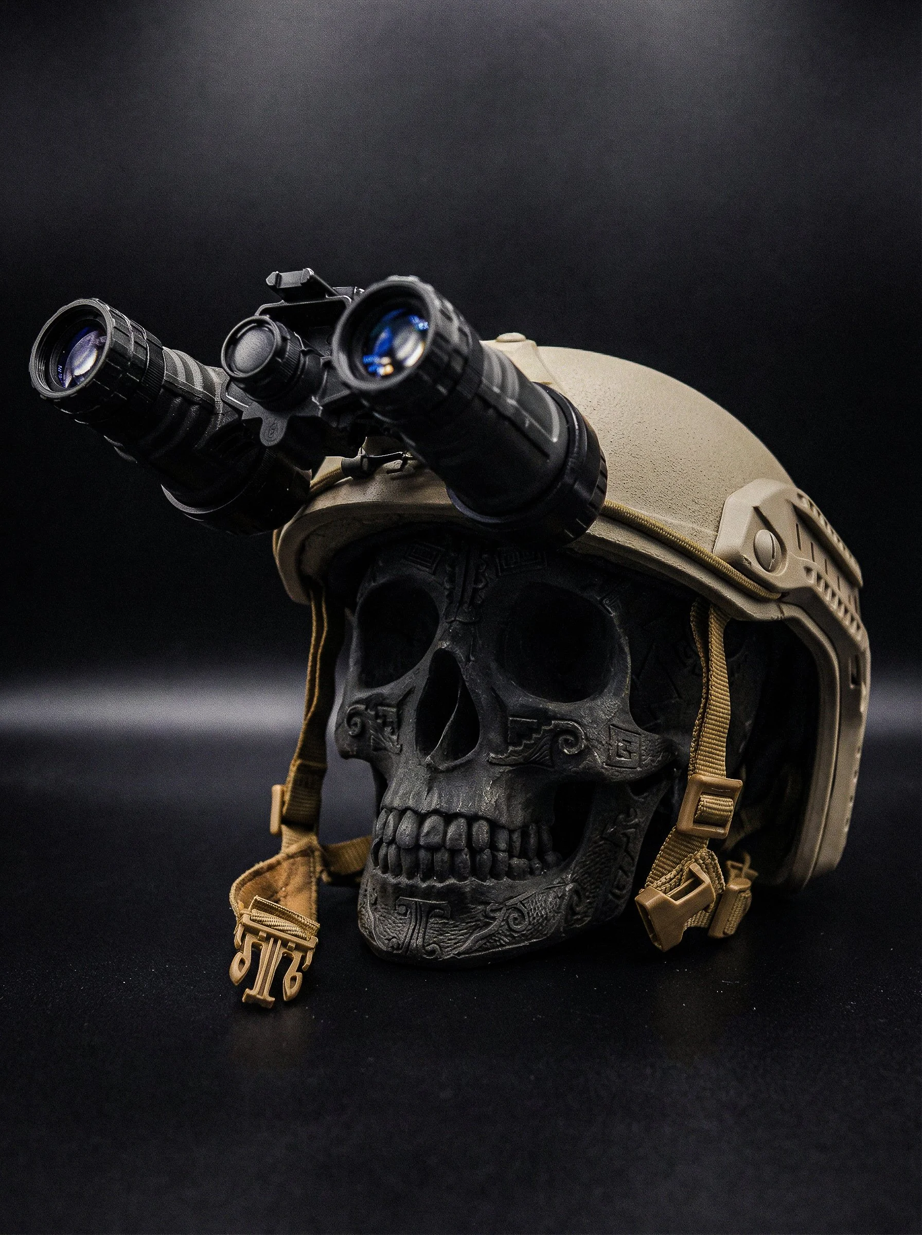 A skull wearing a tan military helmet with mounted night vision goggles, set against a black background.