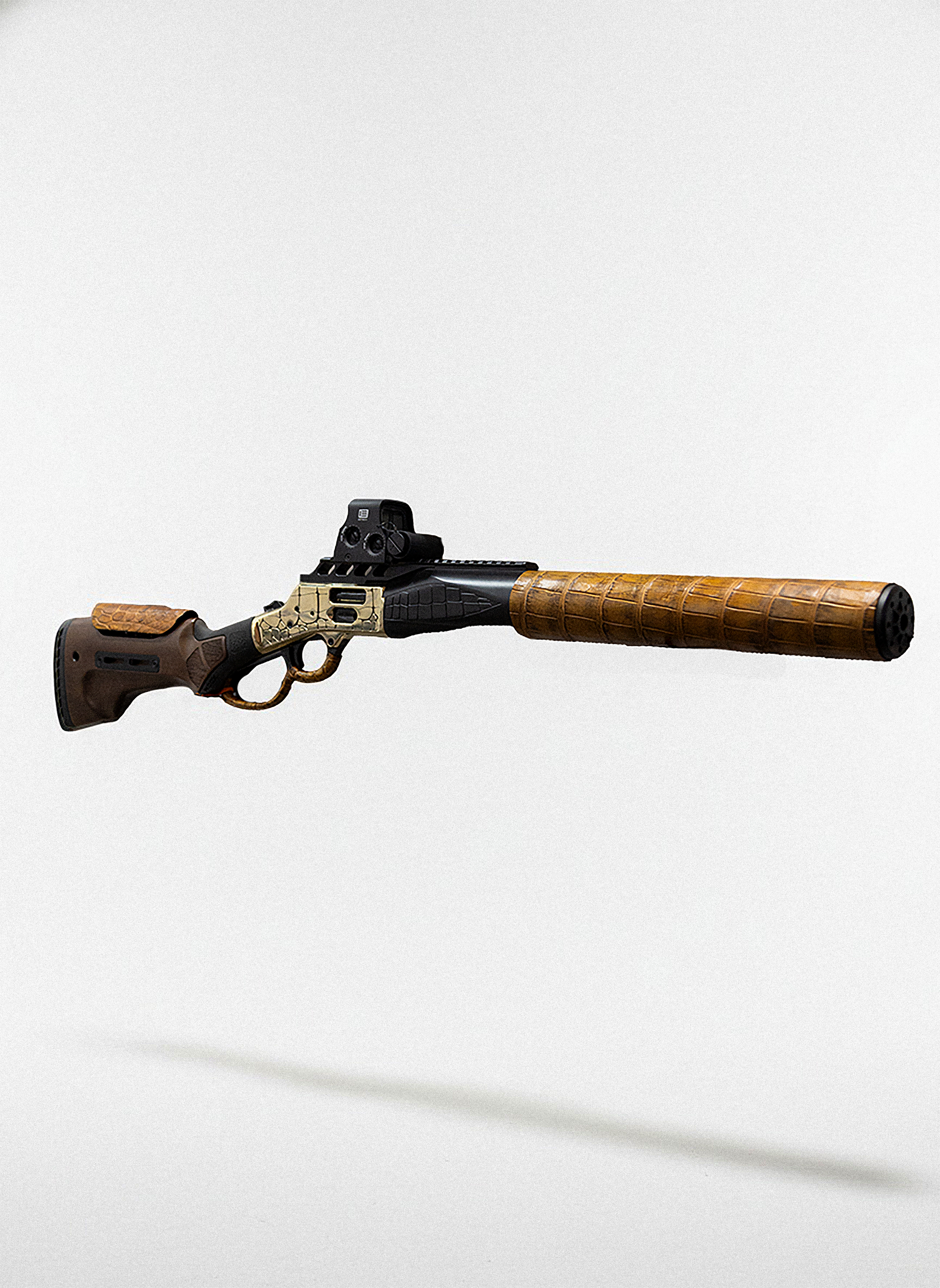 A rifle with a long barrel, tactical attached sight, and wooden stock and grip, lying horizontally against a plain light background.