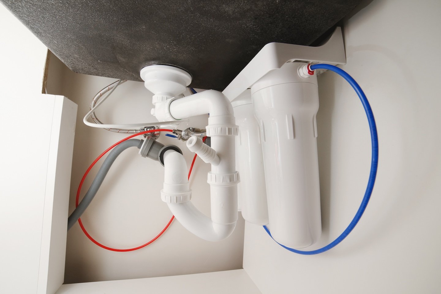 Neat under-sink pipework with new waste pipes and an inline water filter