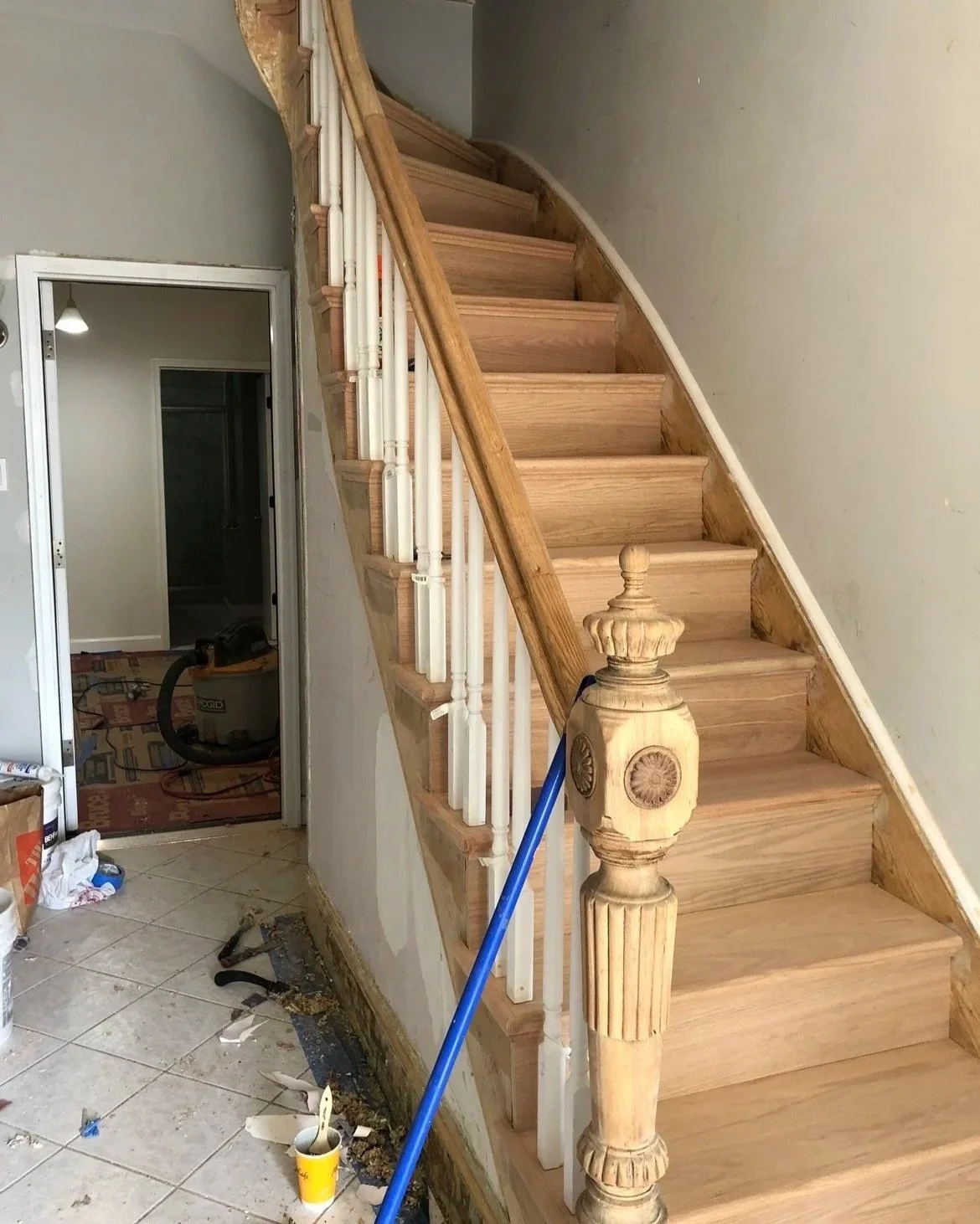 Wooden staircase under renovation with building materials and tools around.