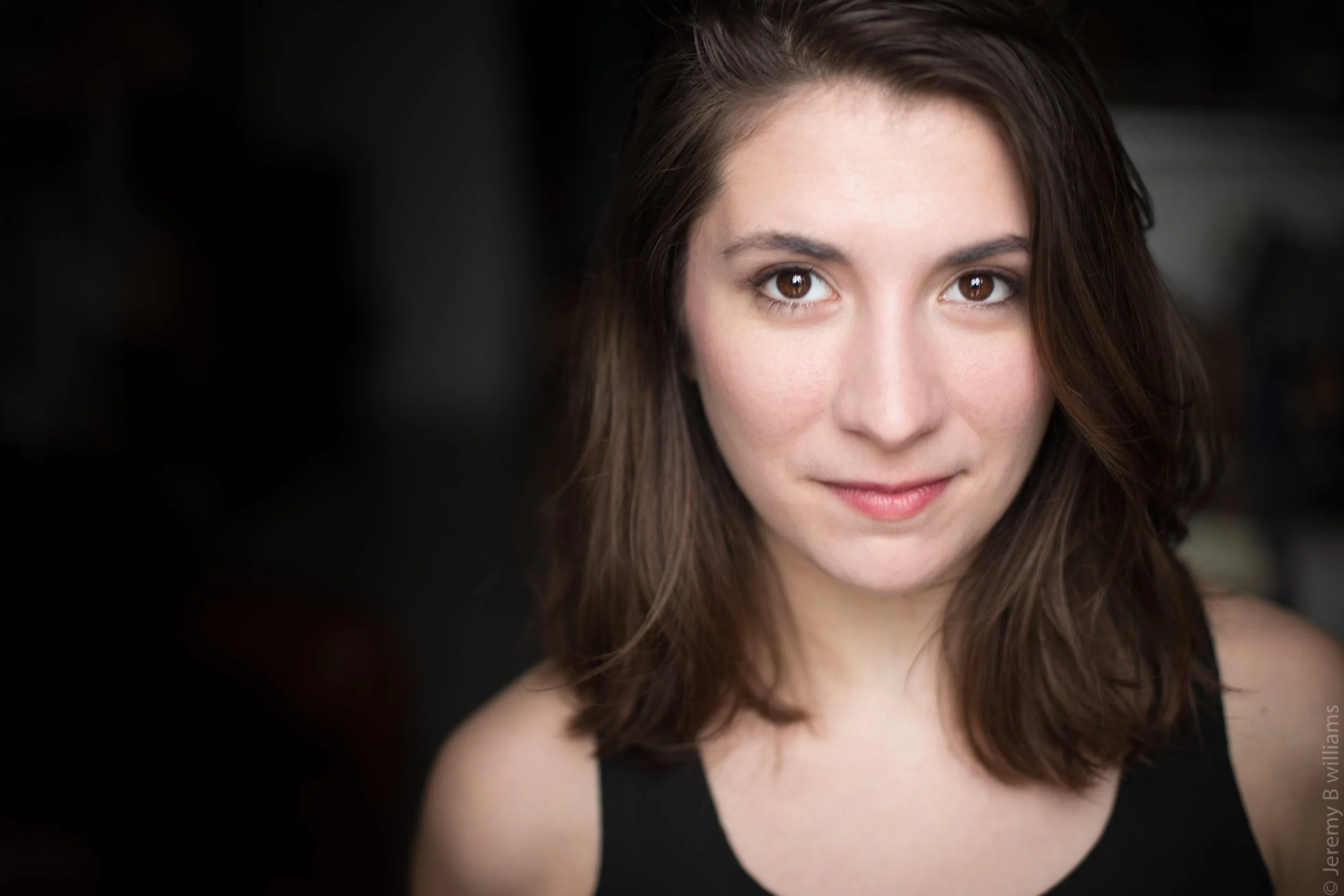 Portrait de Liane, une des fondatrices, jeune femme aux cheveux bruns, souriante.