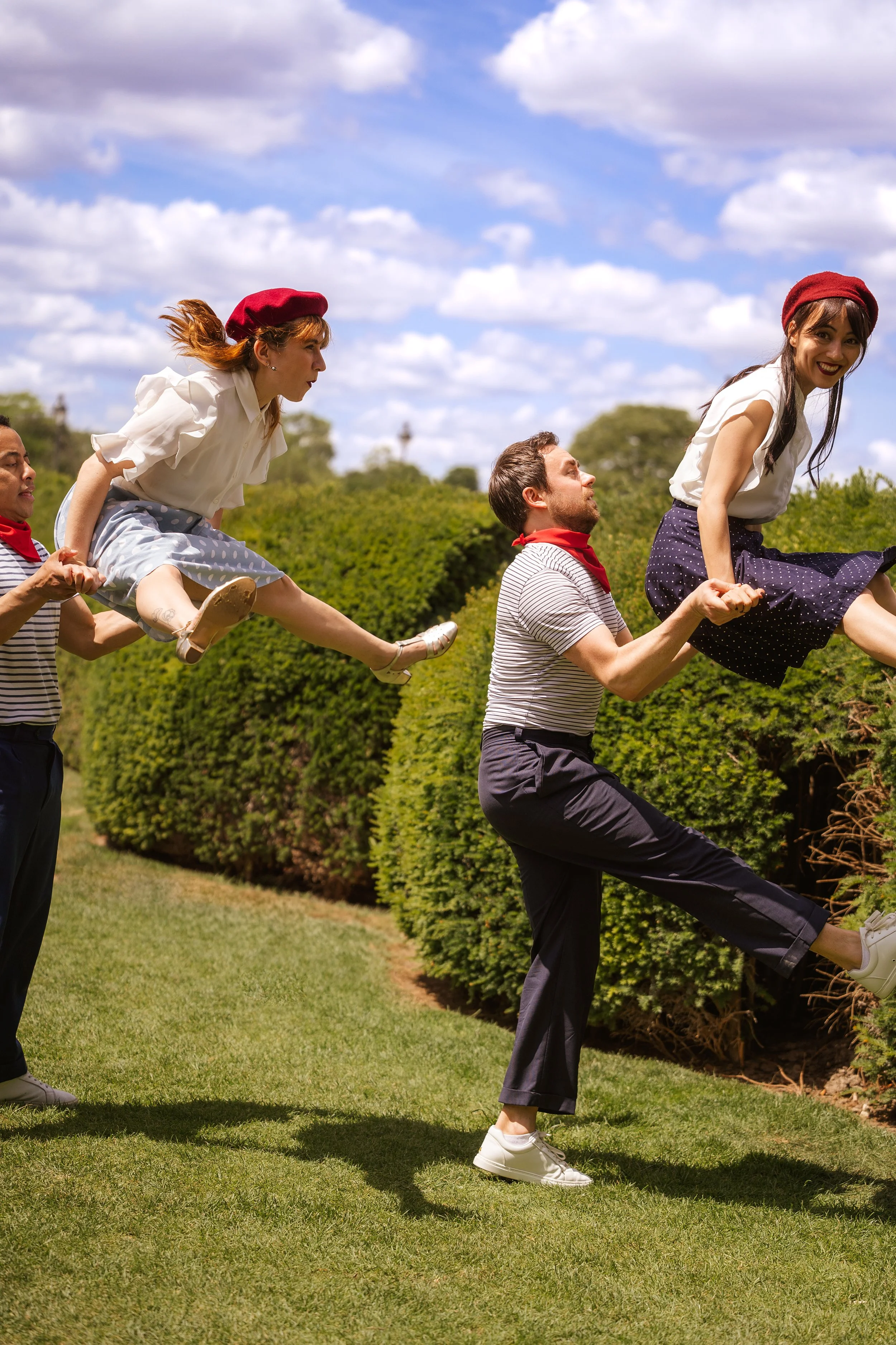Deux couples de danse faisant un porté swing dans un jarding, dans une ambiance guinguette.