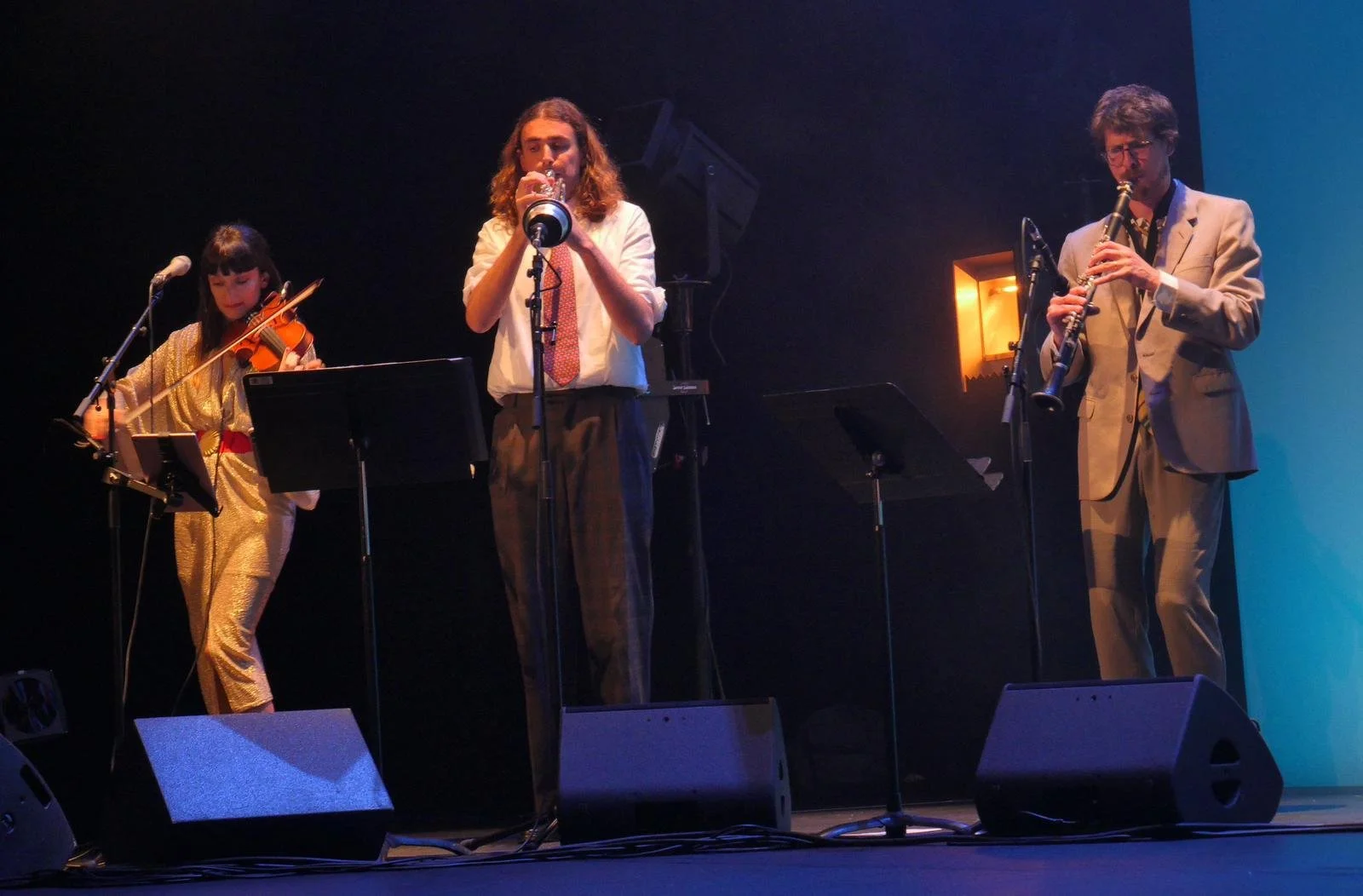 Trois musiciens jazz swing sur scène jouant lors d'un concert