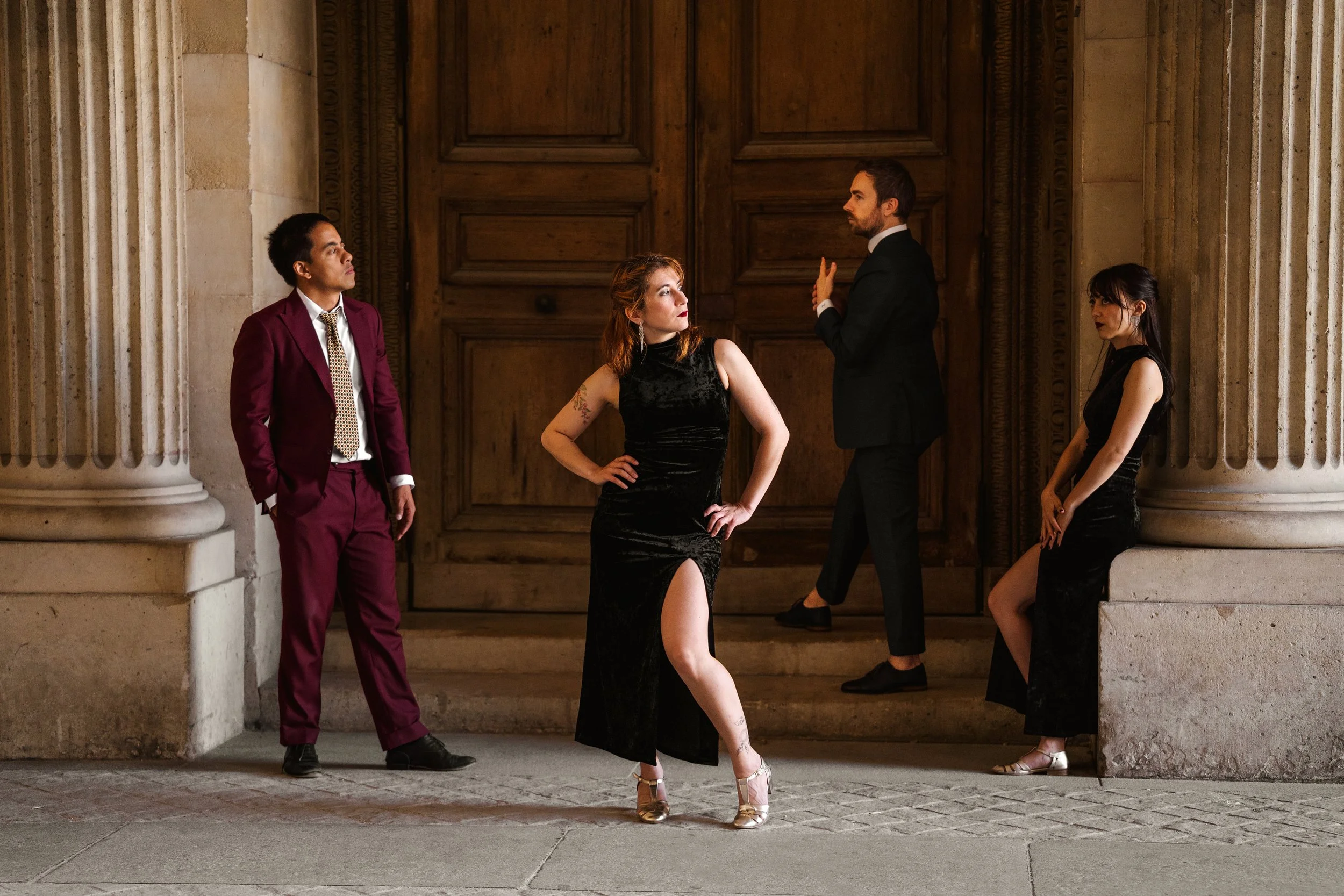 Un groupe de quatre danseurs swing habillées élégamment, dans une ambiance chic et sophistiqué.