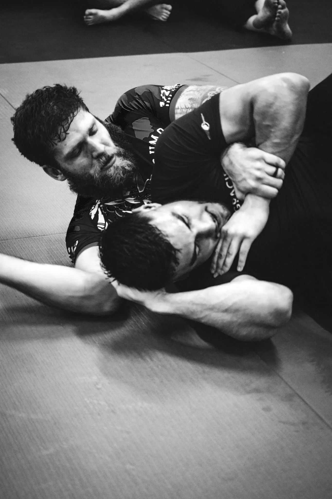 NoGi BJJ class at Queen City Jiu Jitsu — adult students grappling without uniforms