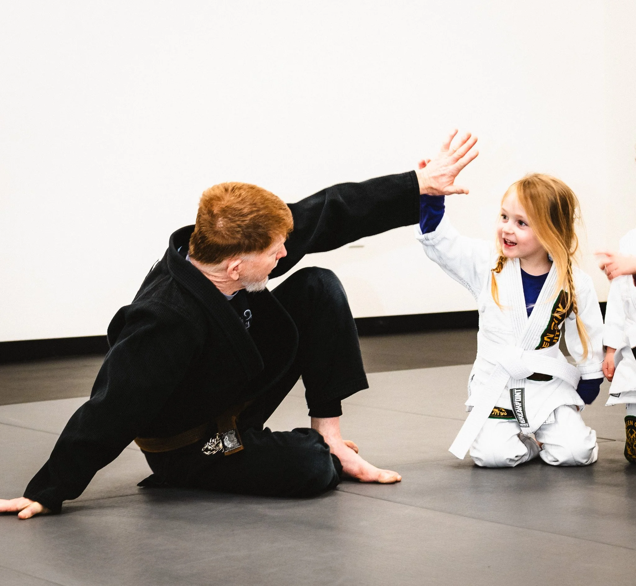 BJJ instructor high-fiving a young student at kids jiu jitsu class in Fort Mill