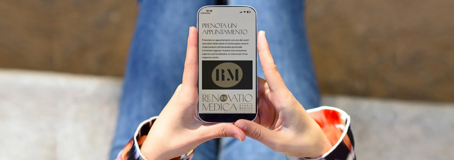 Una persona tiene tra le mani uno smartphone con un'email aperta che promuove la prenotazione di un appuntamento medicale presso uno studio di medicina. Sul display si vede il logo di Renovatio Medica.
