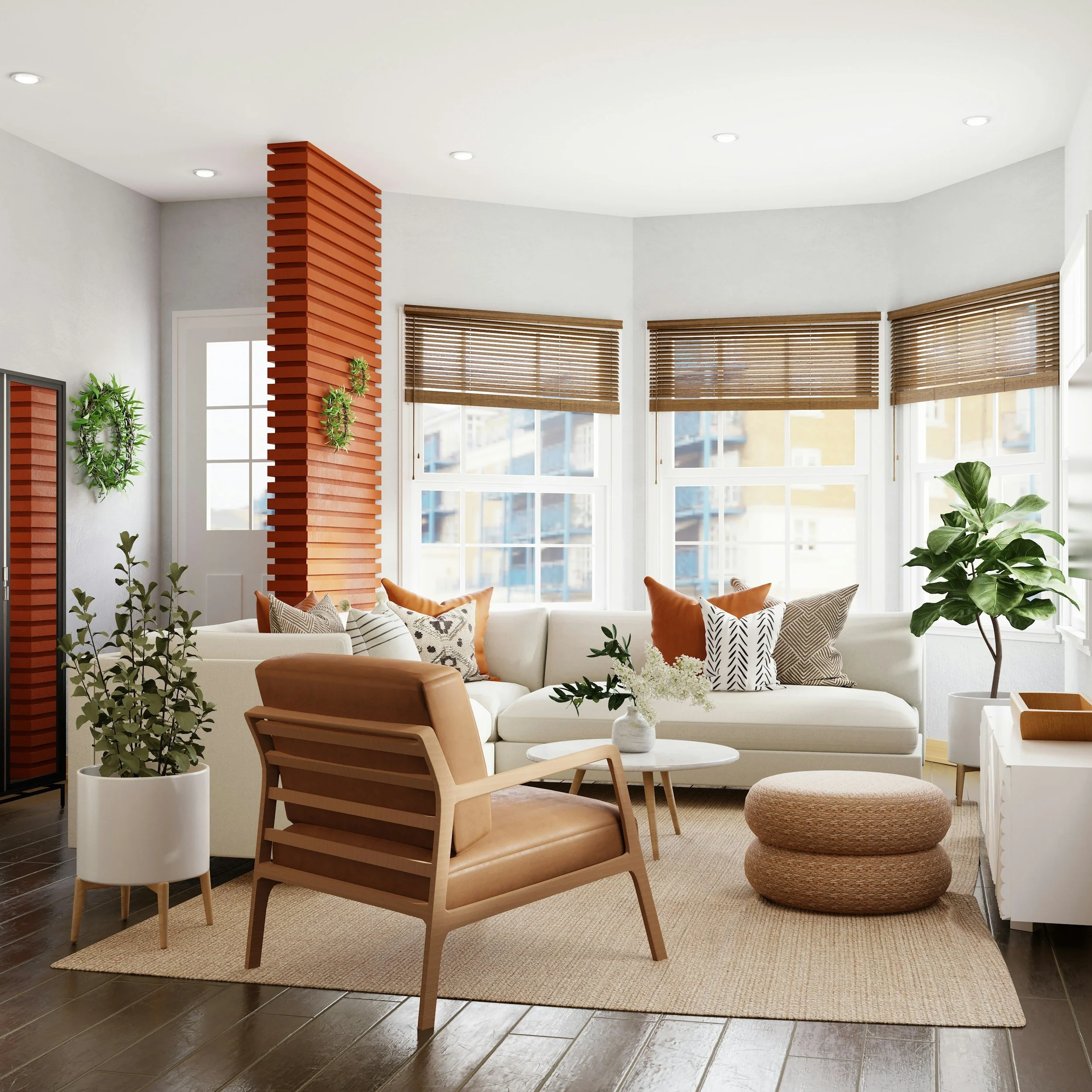 Bright living room with white sofa, wooden armchair, round ottoman, potted plants, and large windows with blinds.