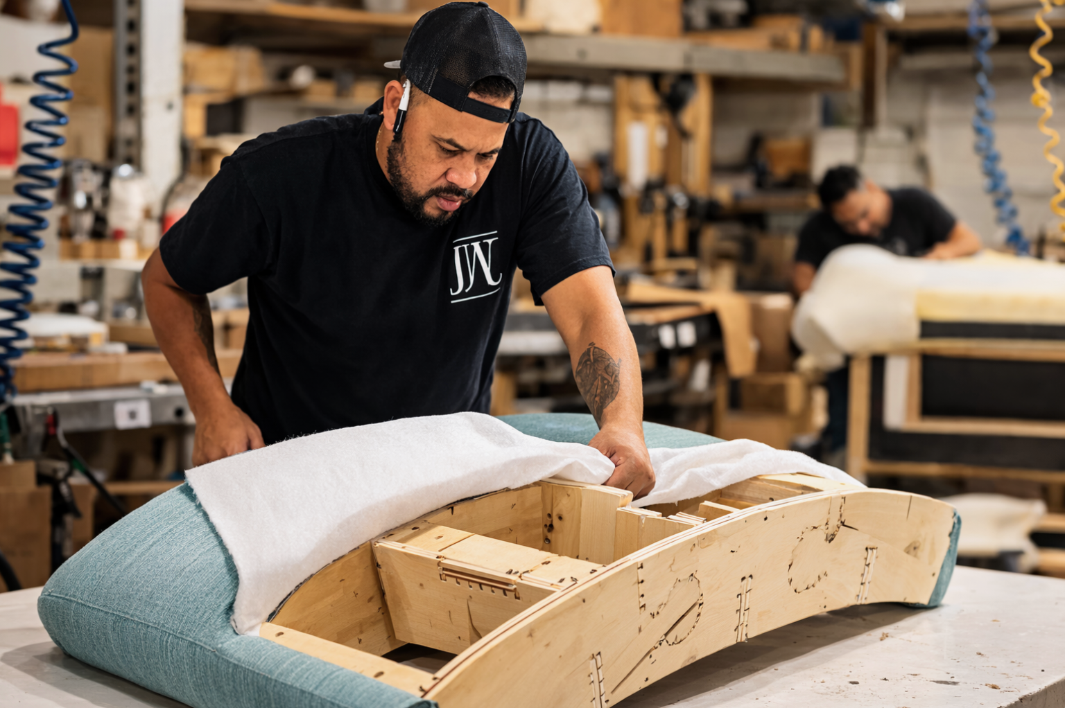 Woman arranging a vibrant floral centerpiece on a table, surrounded by candles and small pumpkins, in an indoor setting.
