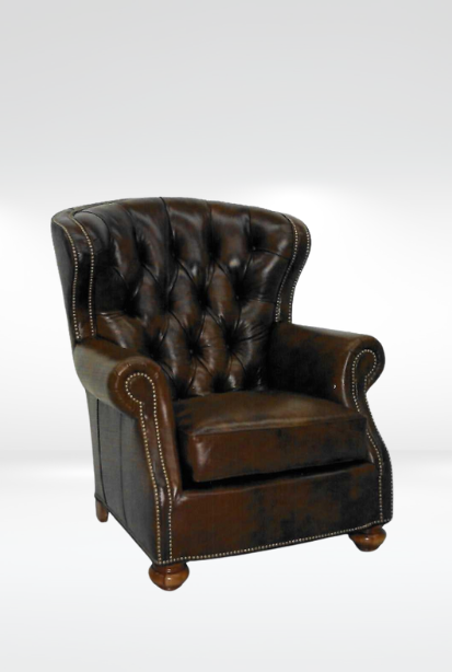 Harrison Chair || A dark brown leather armchair with a tufted back and brass nailhead trim, set against a plain white background. 
