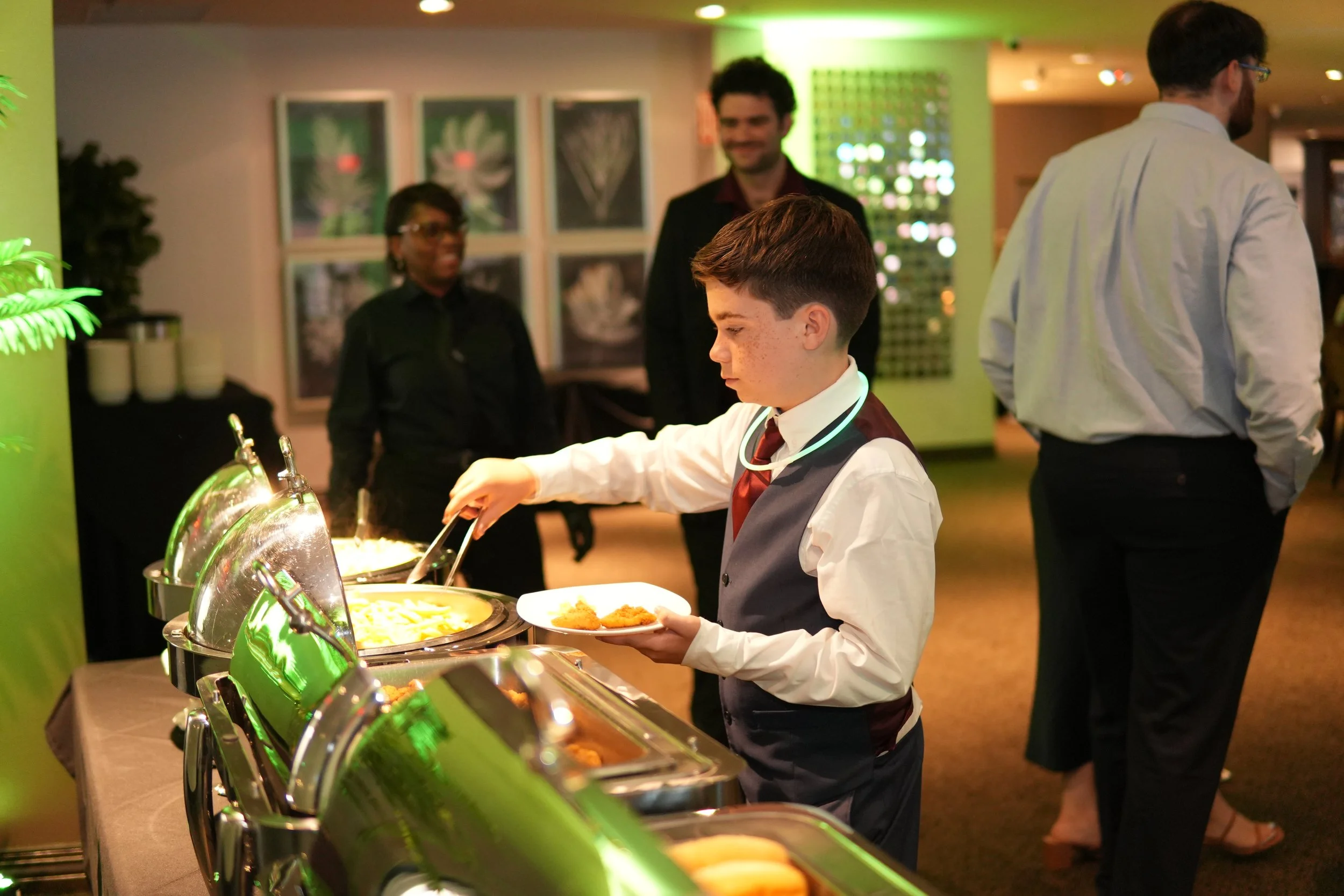 birthday boy grabbing food from buffet