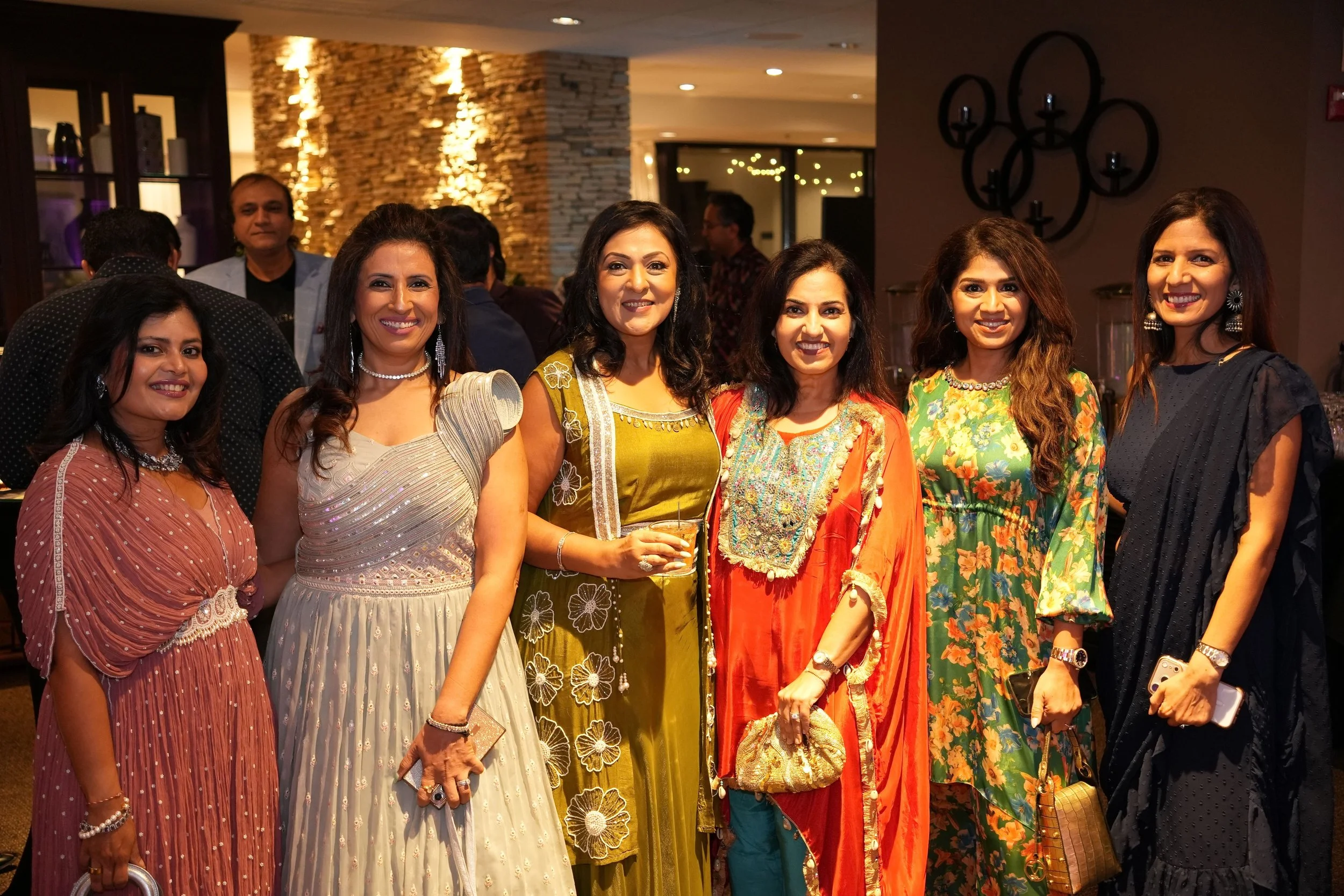 four women pose for picture in cultural attire