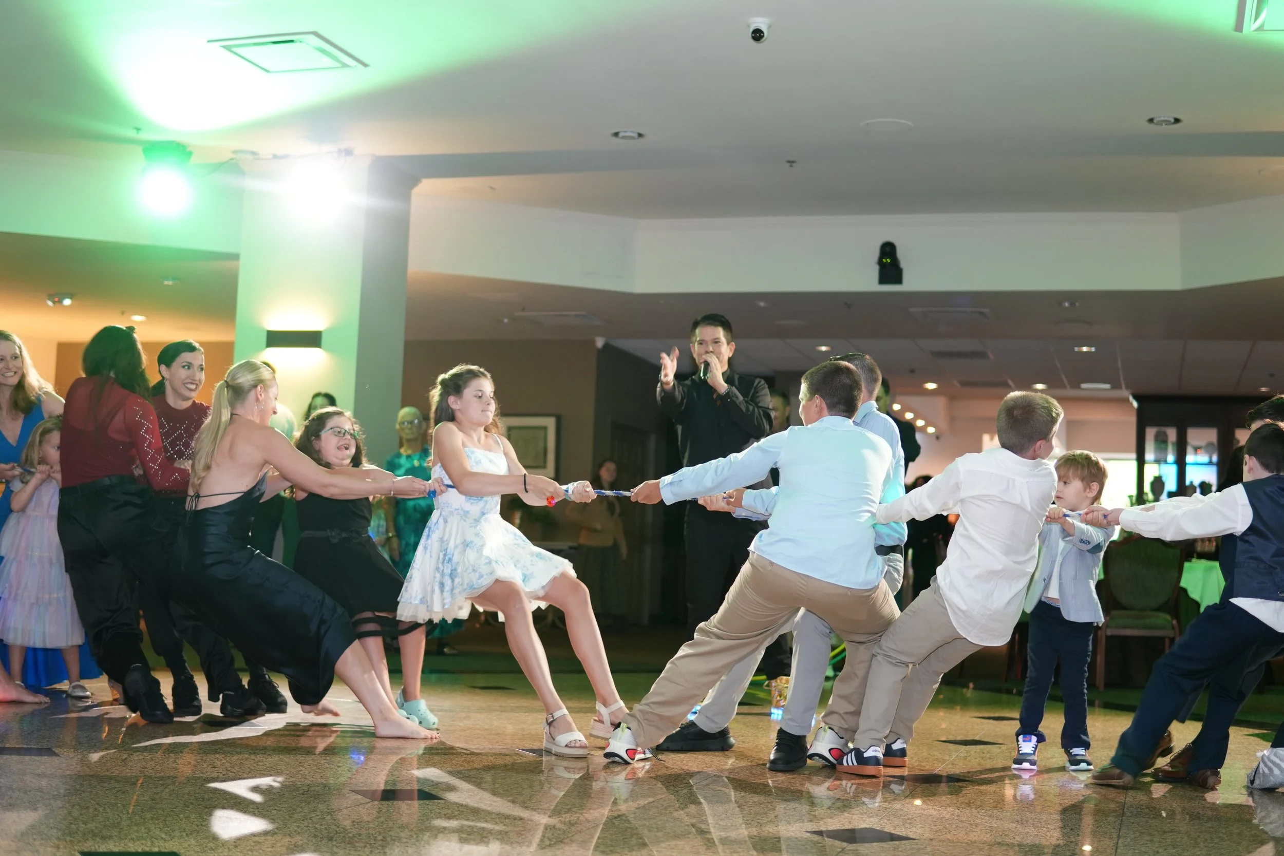 party guests play tug-of-war on dance floor