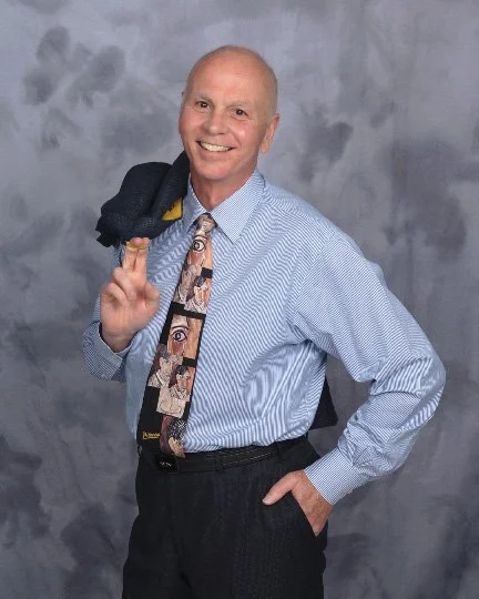 "Simple Strategic Planning" author Phil Wilton smiling casually with his jacket over his shoulder