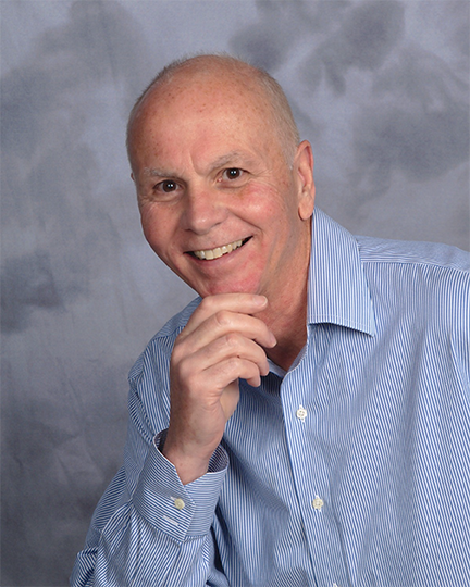 Strategist and author Phil smiling casually, inviting readers to learn more about his background.