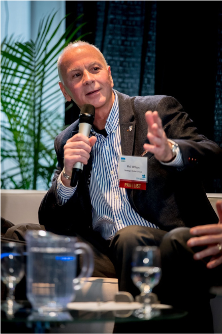 Strategist Phil Wilton presenting a keynote address to a large conference audience.