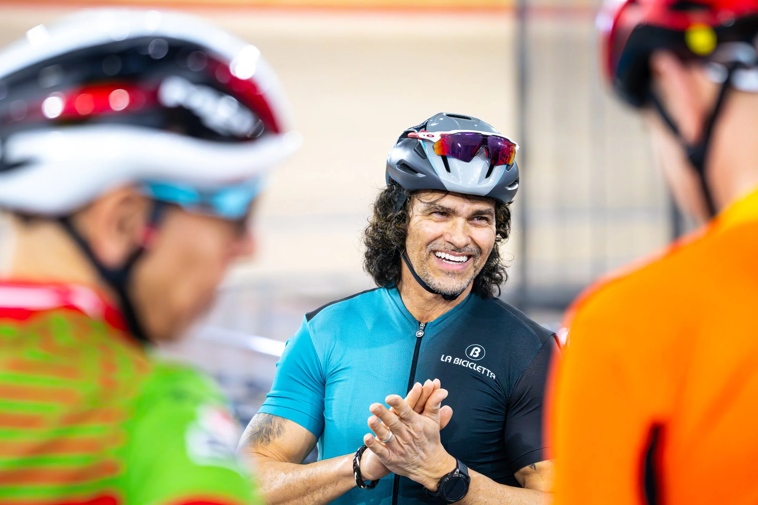 A smiling man in a blue cycling jersey with 