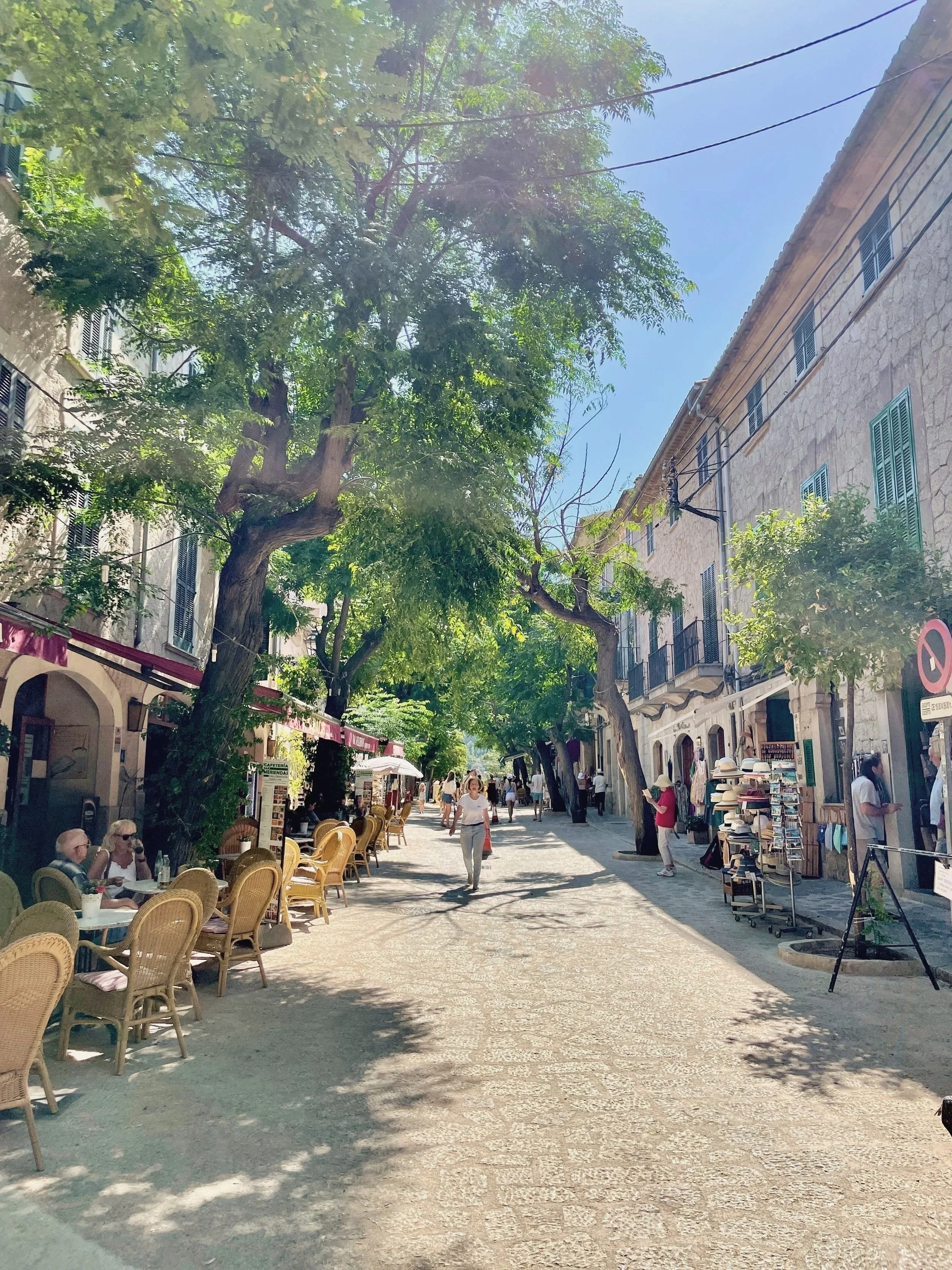 The tree-lined main street of Valldemossa, Via Blanquerna, is lined with cafes and boutiques