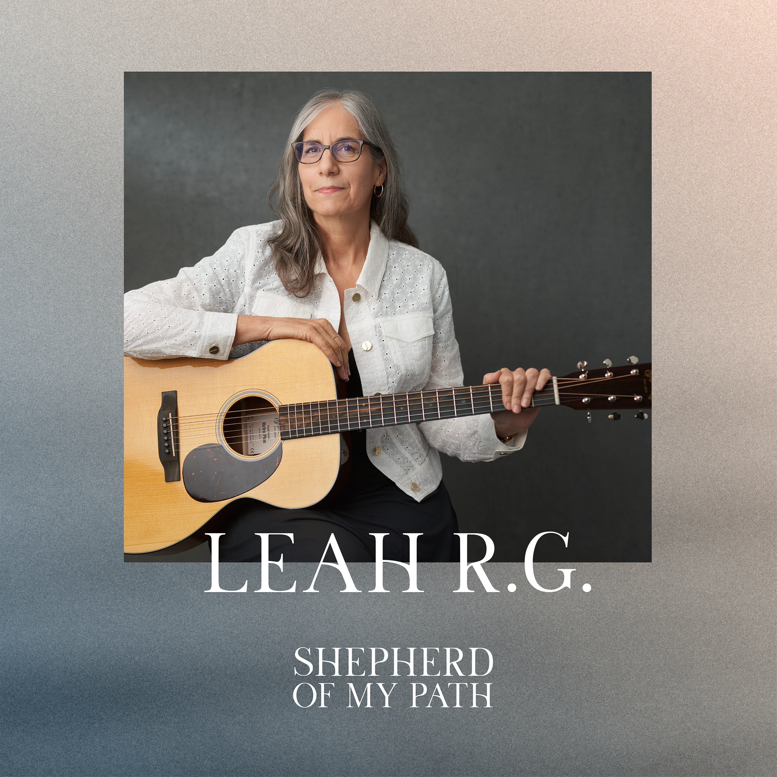 Photograph of Leah R.G. holding an acoustic guitar against a gray background, wearing glasses and a white blouse. Text on the image reads 'Leah R.G. Shepherd of My Path'.