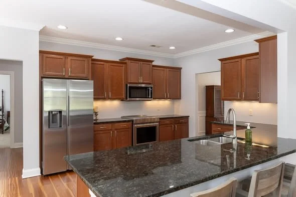 Completed pre-sale home refresh featuring updated lighting painted cabinets and refinished flooring by Mims Construction