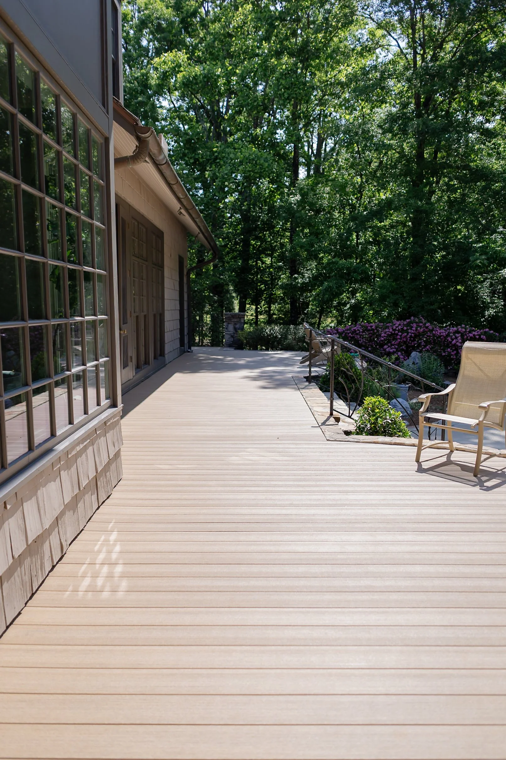 Close-up micro view of premium, high-end composite hardwood outdoor decking material installed on a sloped ridge lot on Lookout Mountain, showcasing a flawless hidden fastening system with zero visible face-screws.