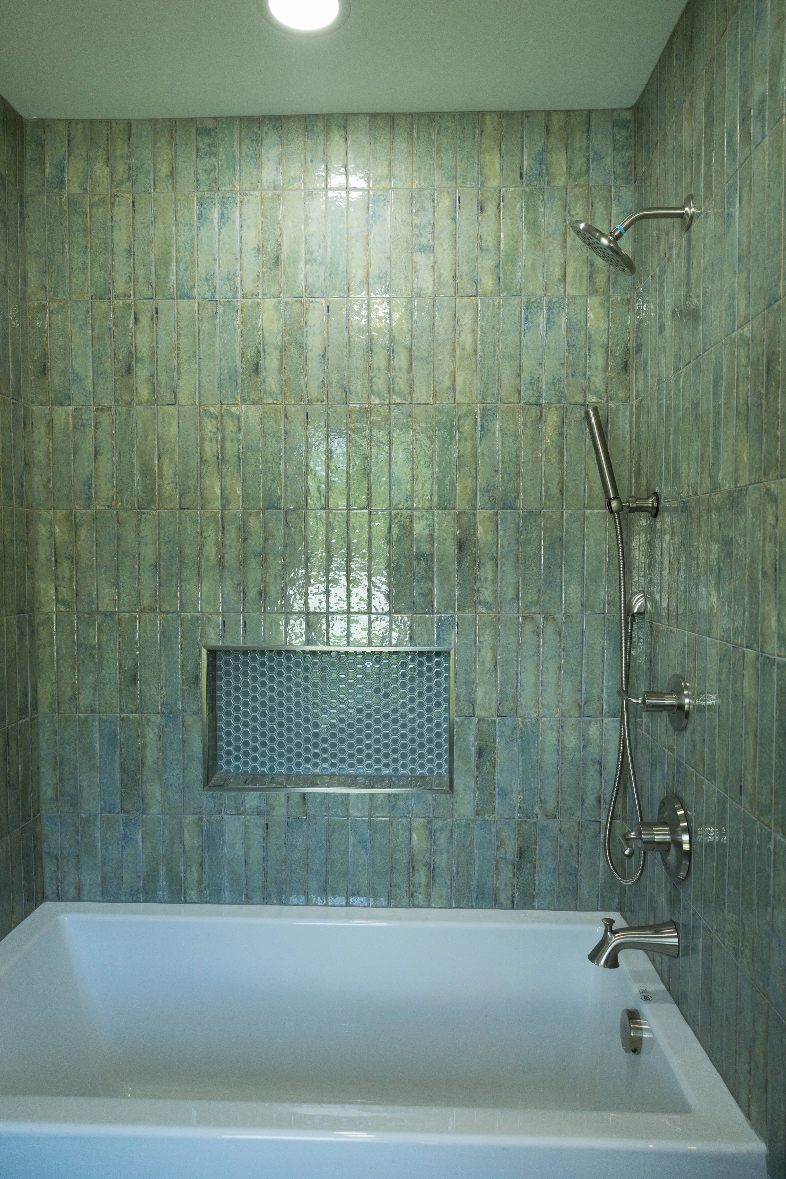 Bespoke primary bathroom renovation in Dayton TN featuring organic green wall tile, an integrated built-in soaking tub layout, custom tile shower configurations, and a recessed built-in shelving cut-out niche.