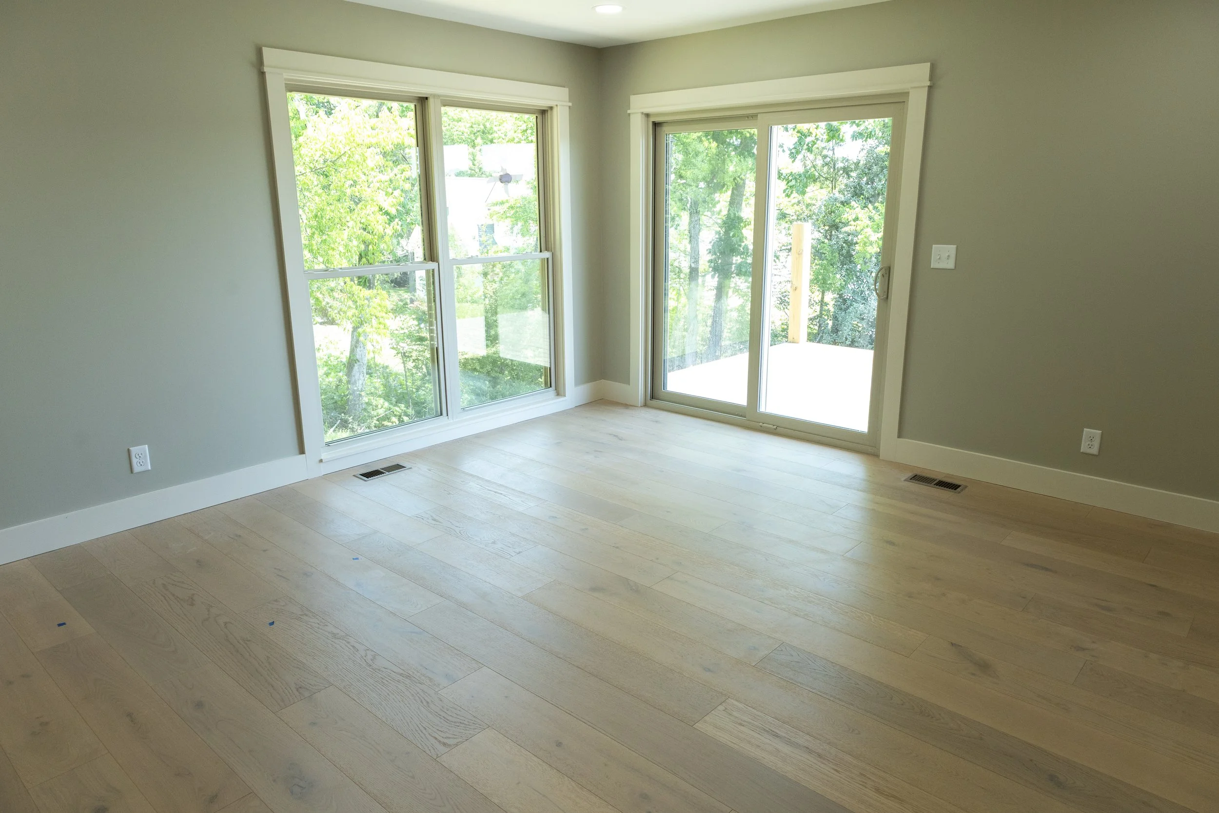 Bespoke residential flooring installation by Mims Construction in Dayton TN, demonstrating a clean, perfectly flush, millimeter-precise layout transition between natural custom hardwoods and heavy premium tile.