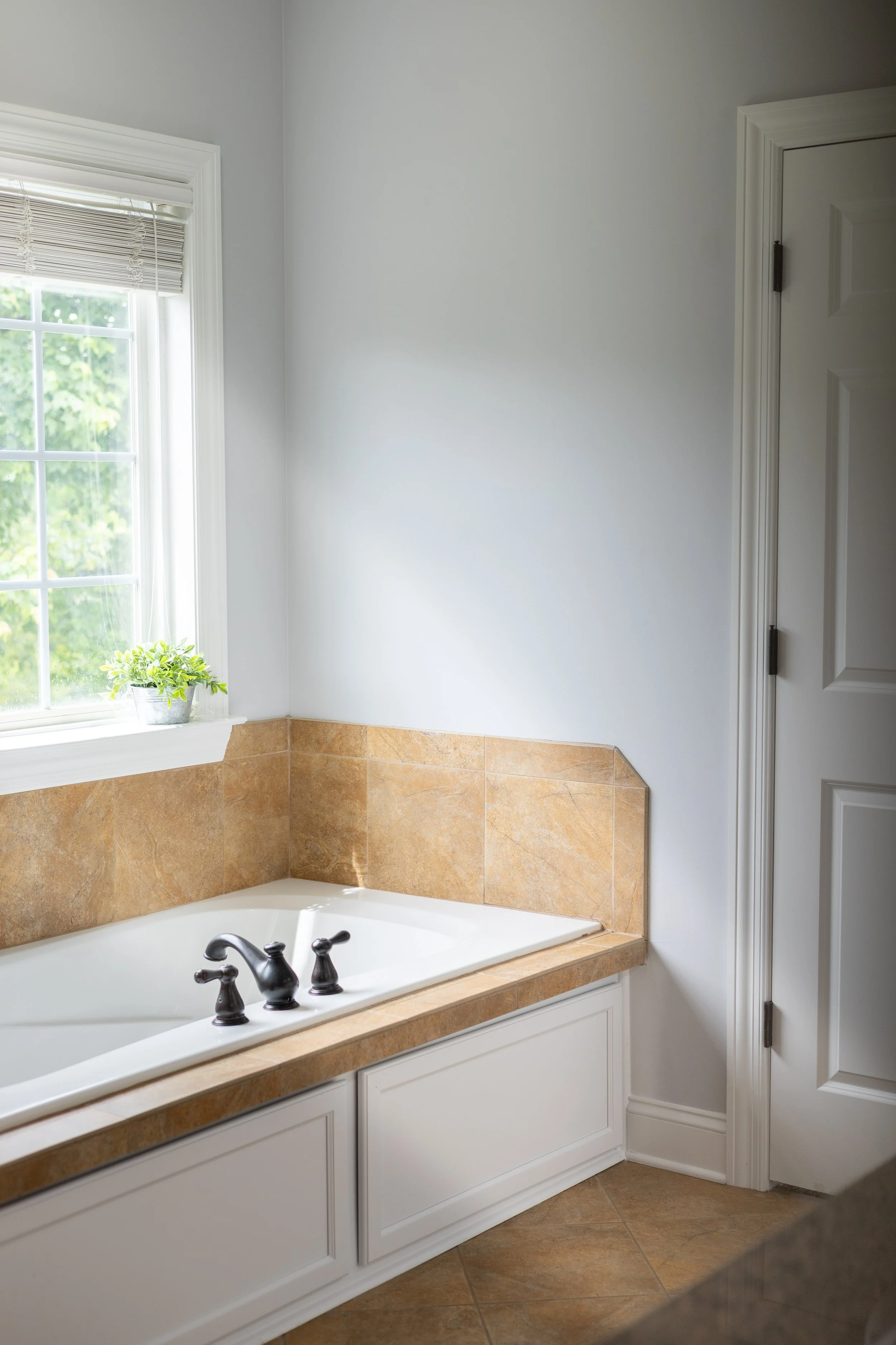 Corner built-in jet tub renovation with updated crisp white cabinetry trim and deep-cleaned custom tile surrounds, executed by Mims Construction to increase home valuation and market appeal in Ooltewah TN.