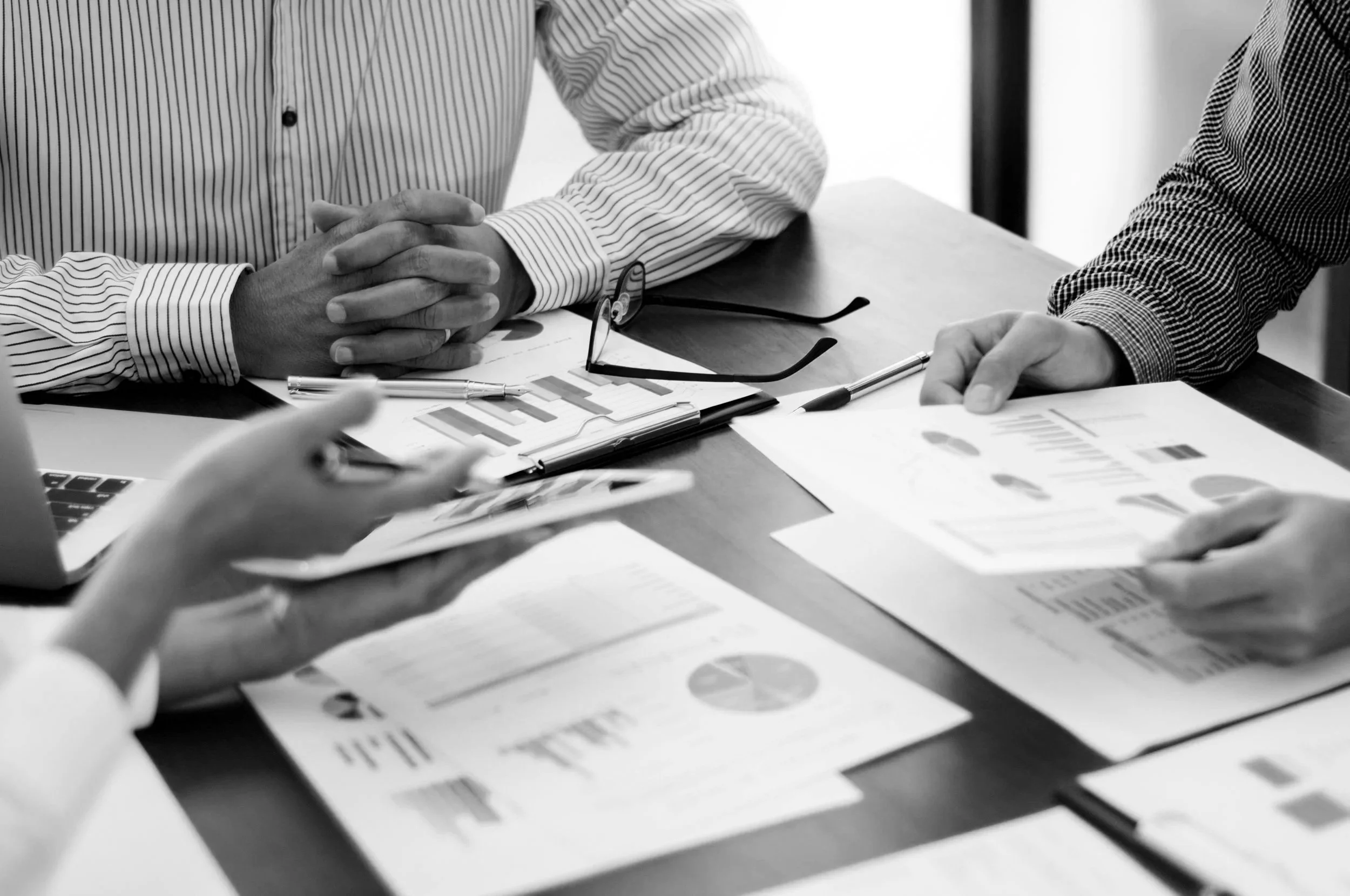 Business professionals discussing financial charts and graphs in a meeting.