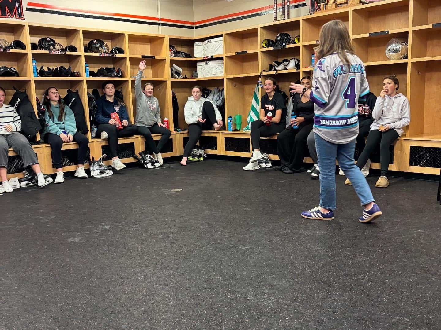 Angela Drake Speaking in front of hockey players
