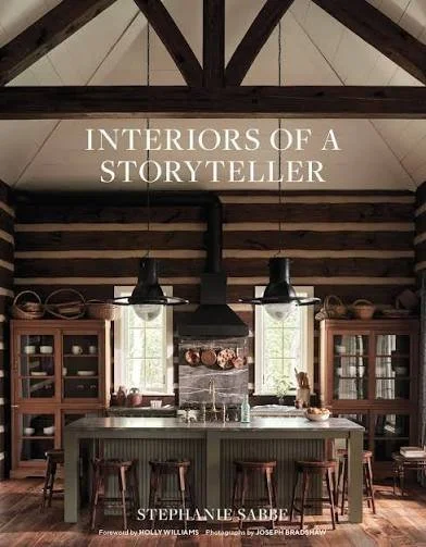 Interior view of a rustic kitchen with wooden cabinets, a central island with bar stools, and large windows letting in natural light, with the text 'Interiors of a Storyteller' at the top.