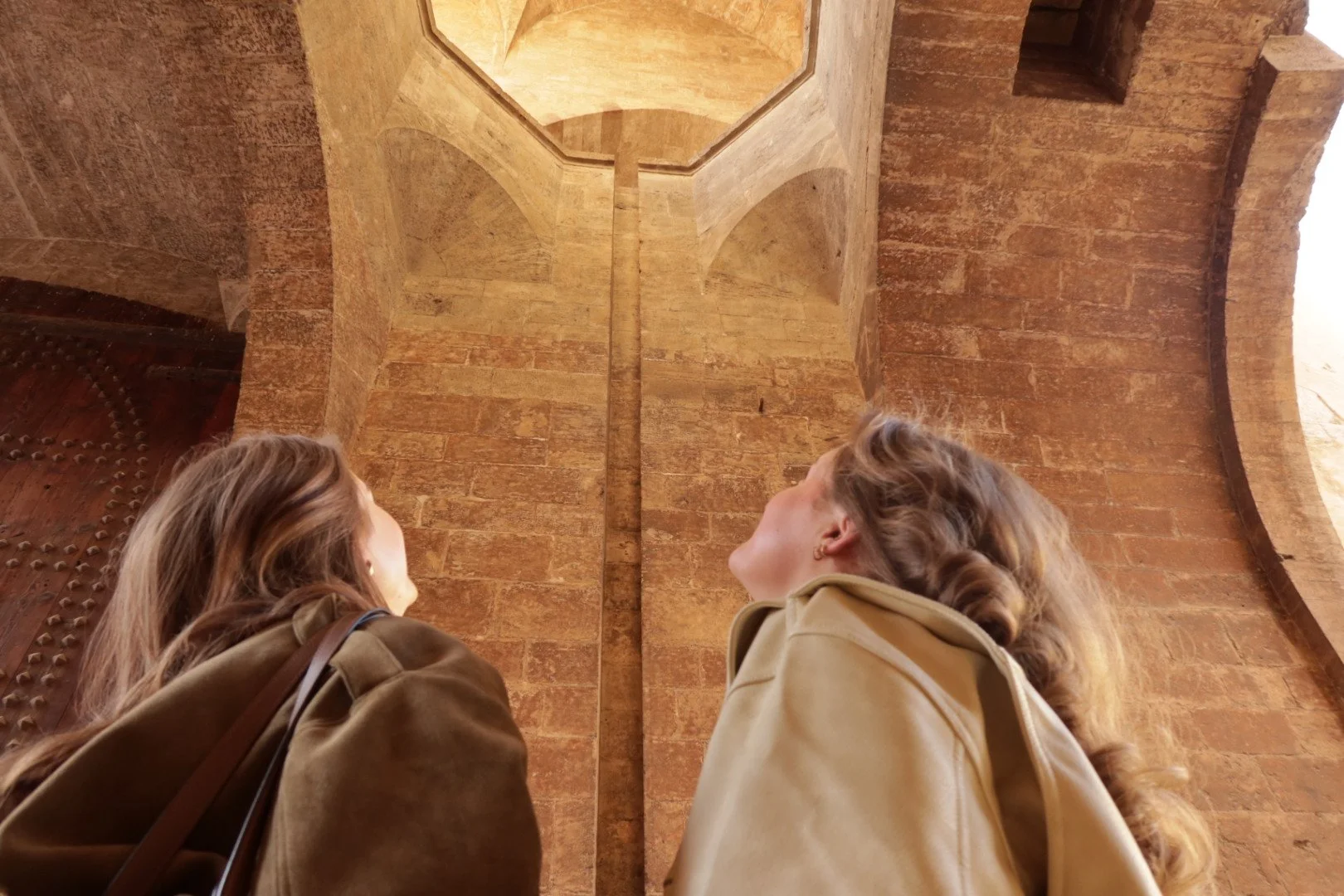 Two women looking at a medieval tower in Valencia old town, Ciutat Vella