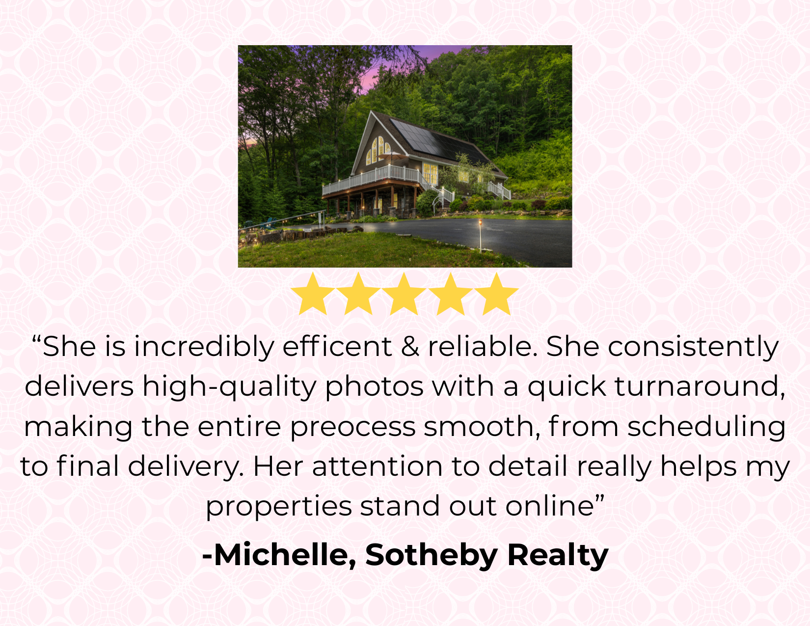 A two-story house with a black roof, solar panels, and large windows is situated among green trees and overlooking a driveway, at dusk or dawn with a pink and purple sky.