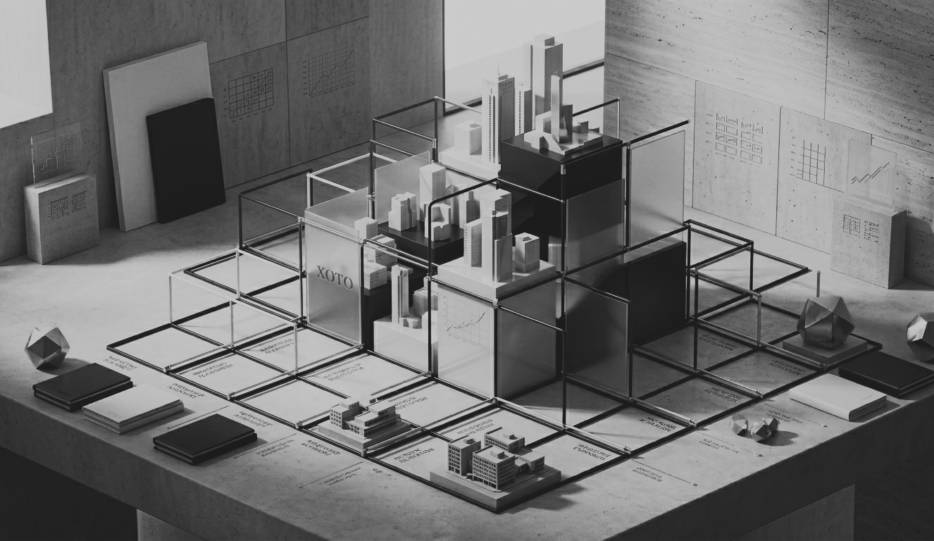 Black and white architectural model of a city with buildings, graphs, and charts on the walls, scattered geometric sculptures, and some booklets on the table.