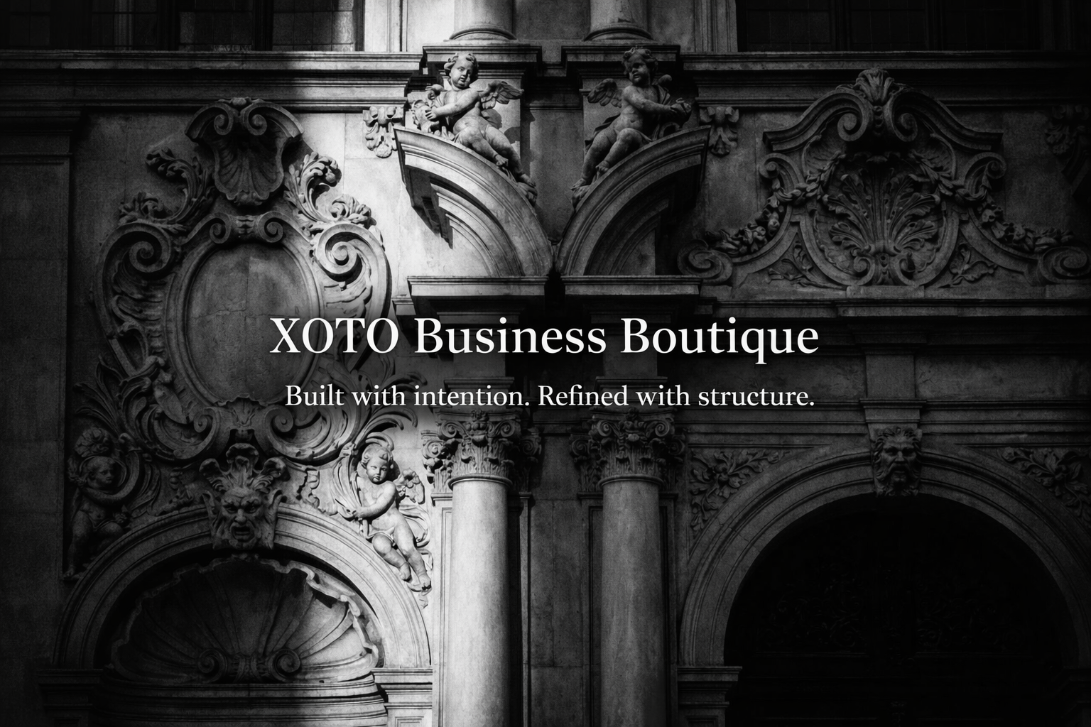 Black and white photo of ornate classical architectural details with cherubs, columns, and decorative sculptures. Overlaid text reads 'XOTO Business Boutique' and 'Built with intention. Refined with structure.'.