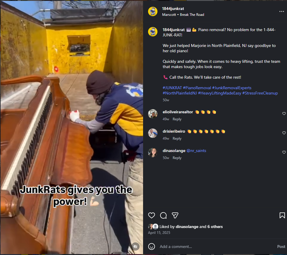 Person wearing a jacket and beanie, using gloves, lifting a piano onto a truck with yellow walls in the background.