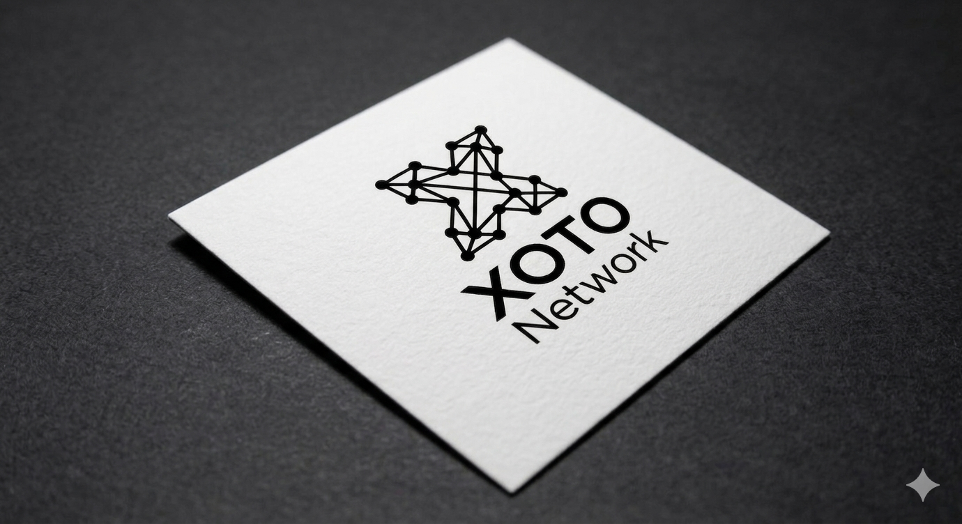A white square card with a black network star logo and the words "XOTO Network" printed on it, placed on a dark surface.