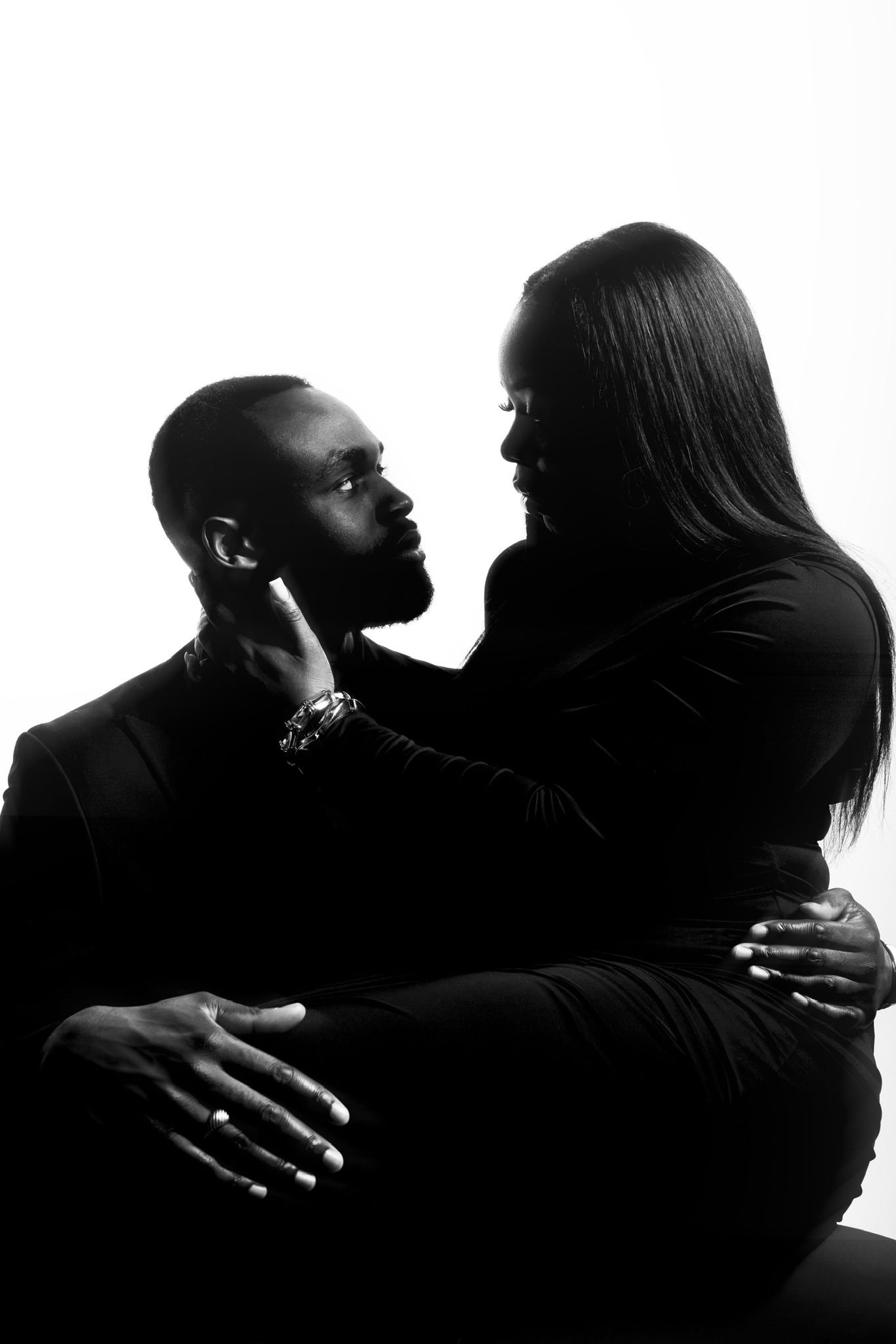 Une femme et un homme se regardant tendrement, en noir et blanc, dans une pose intime.