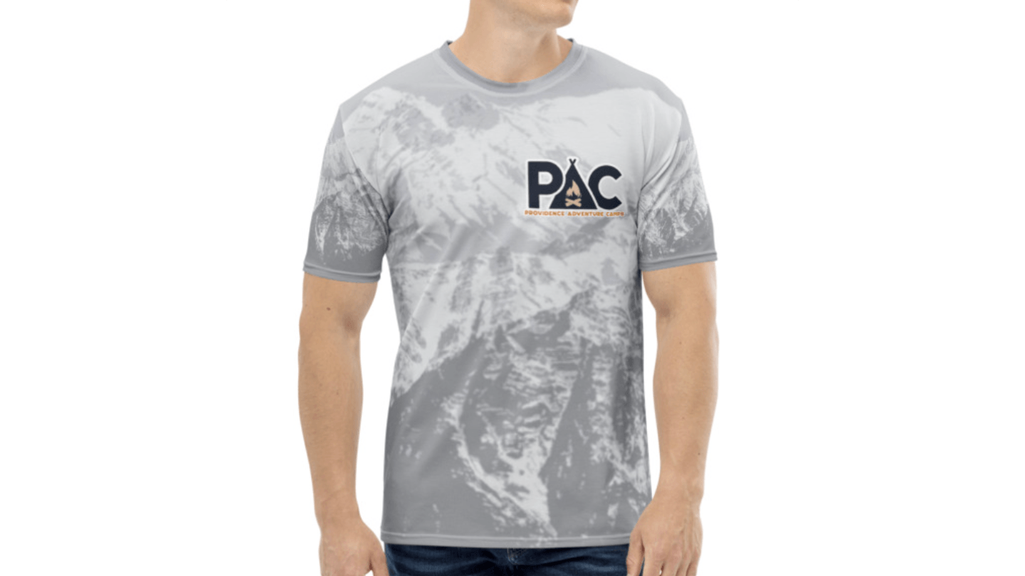 Custom t-shirt design for Providence Adventure Camps — gray and white mountain landscape pattern with 'PAC' logo and campfire tent icon on the chest. All-over print on athletic-style shirt. Designed by Heather at Genuine Midwest Consulting.