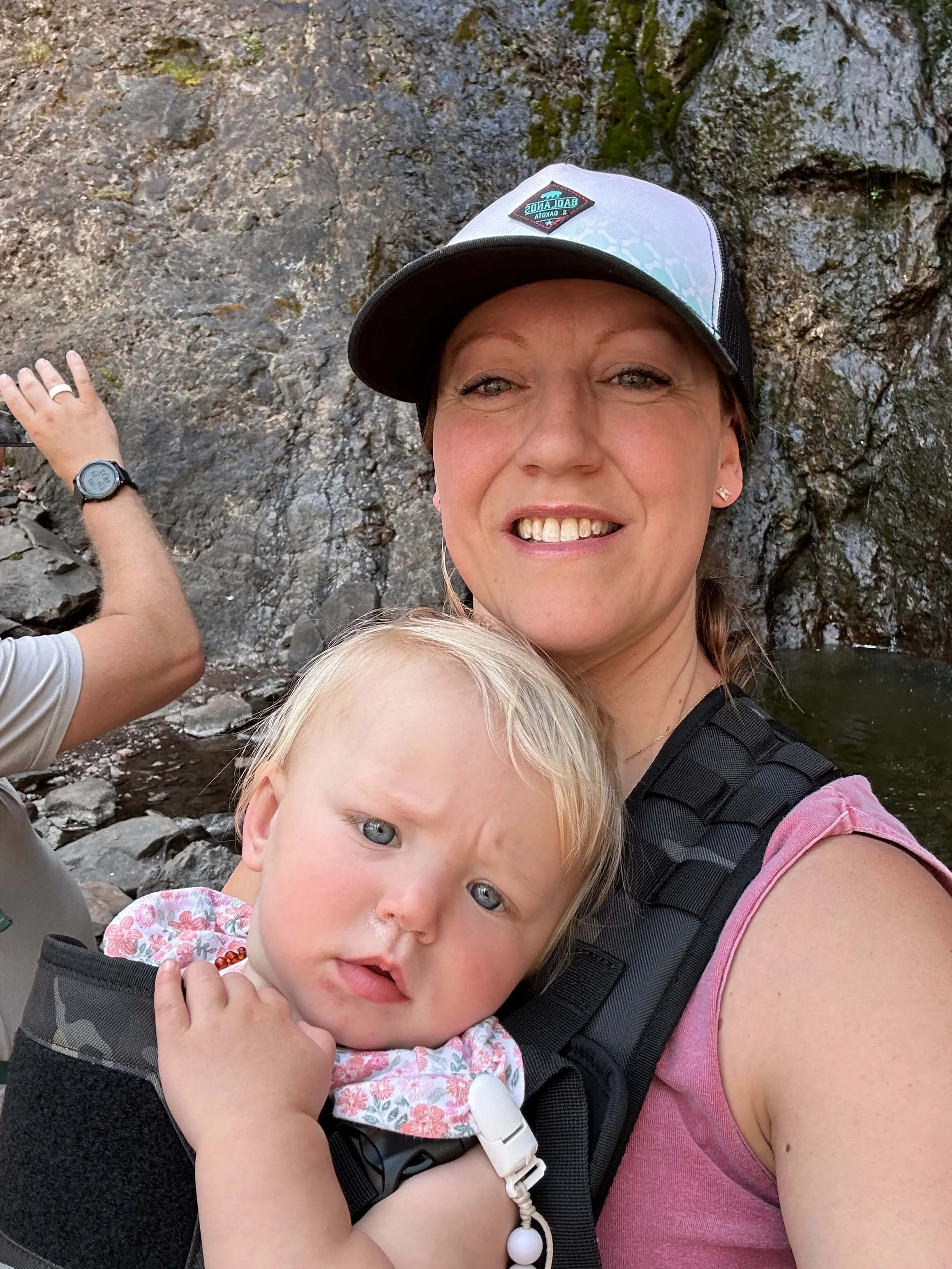 Heather and her youngest baby girl smiling together during a family mountain adventure — warm, genuine moment in nature. About Heather at Genuine Midwest Consulting