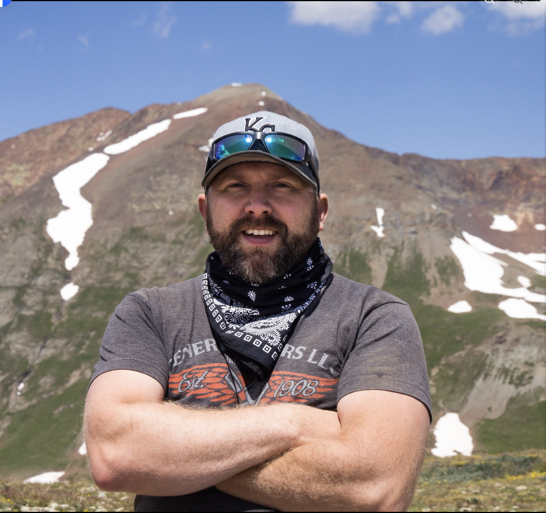 Handsome, strong man with mountain in the background. Website and logo client of Genuine Midwest Consulting, designs by Heather.