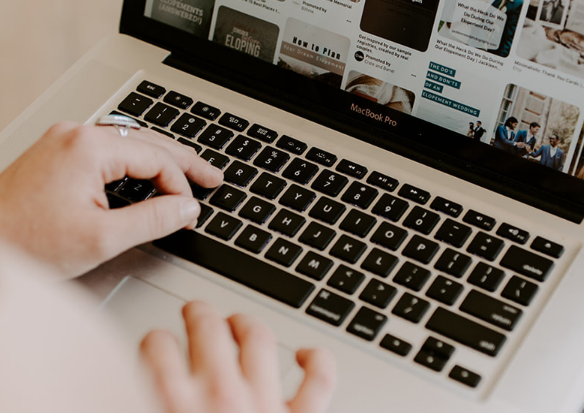 typing on computer to search for wedding vendors