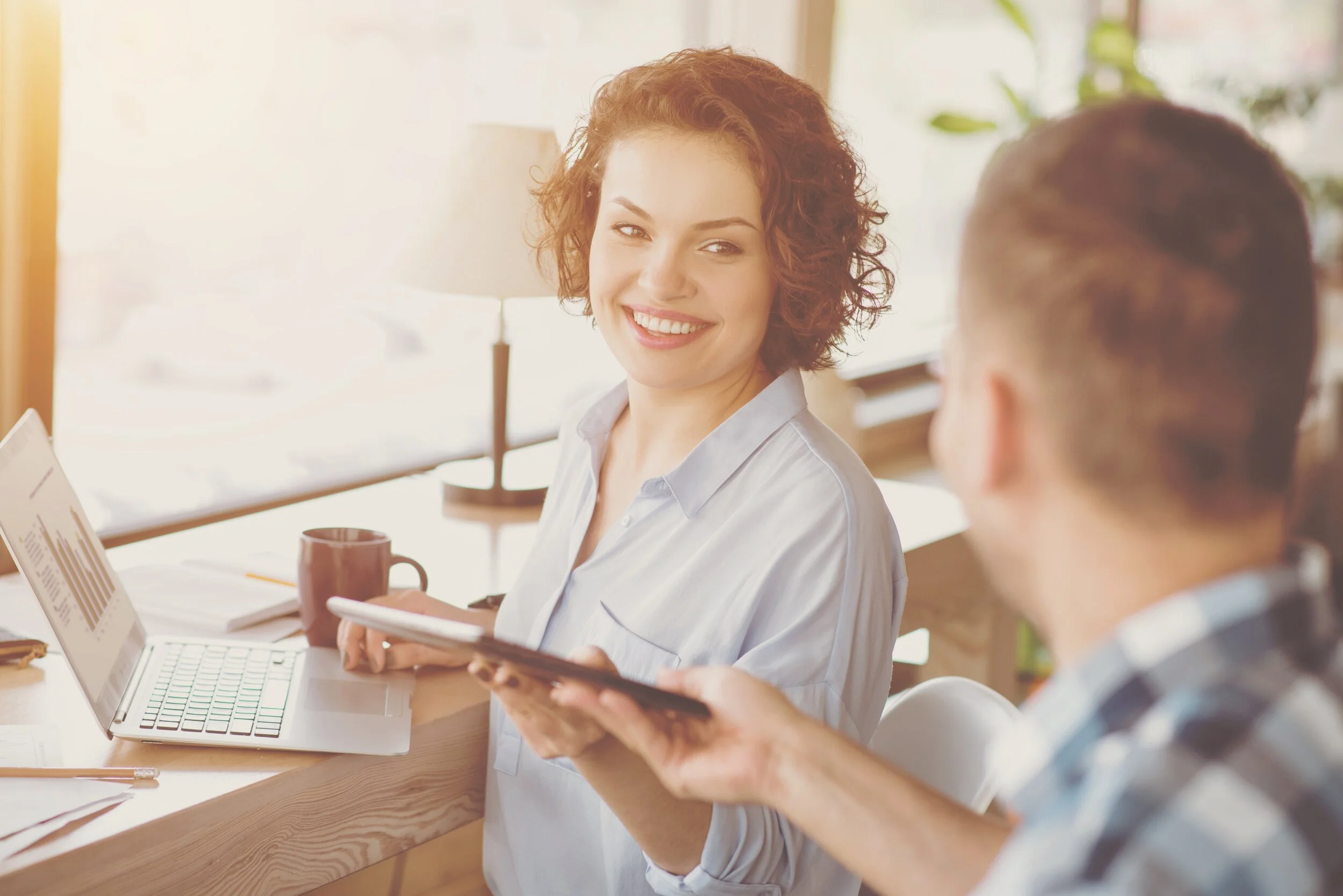 Woman handing a man a tablet